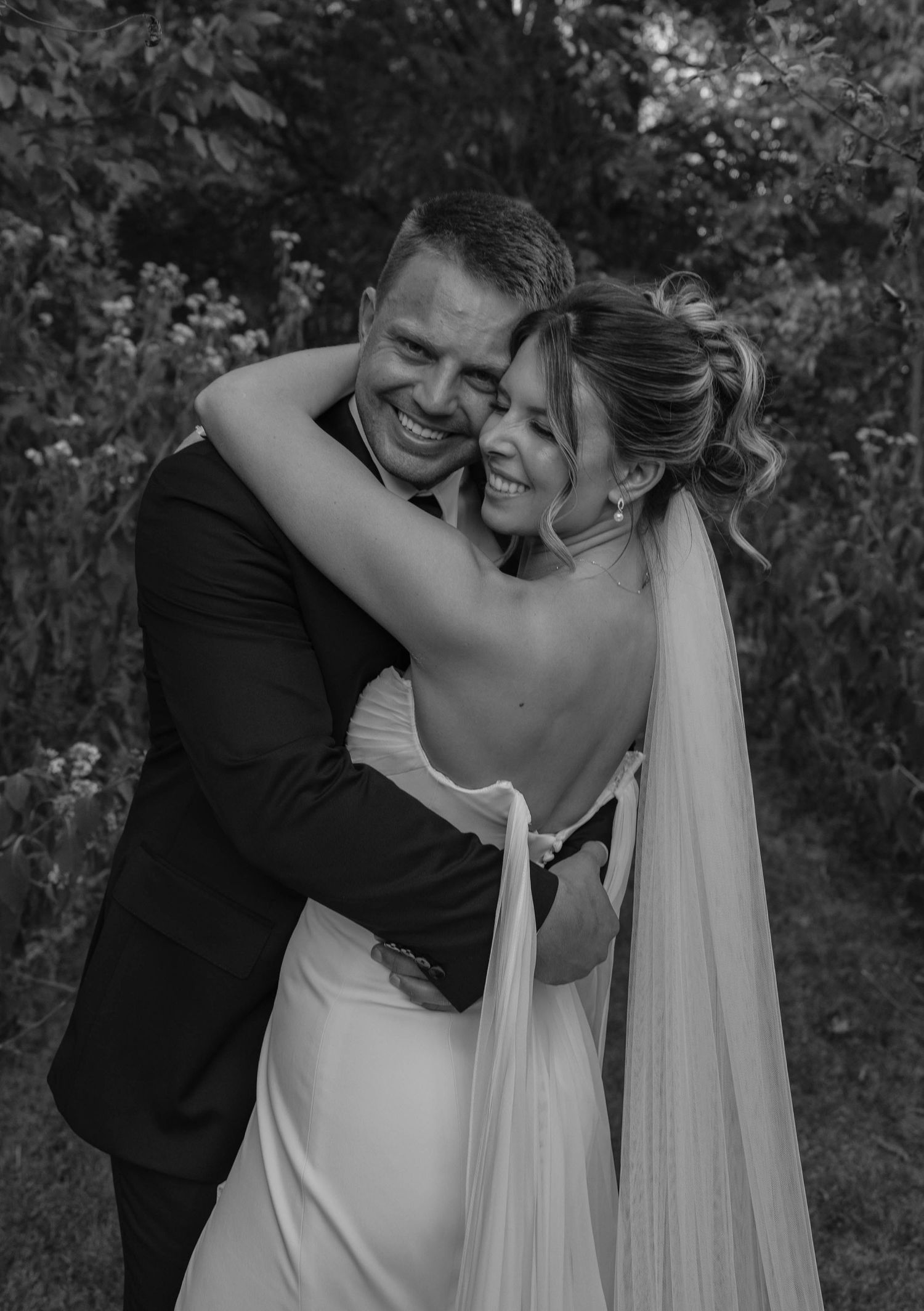 Birmingham Alabama Photographer capturing bride and groom huggin in a field, at Iris Woods Venue in Nashville, Tennessee
