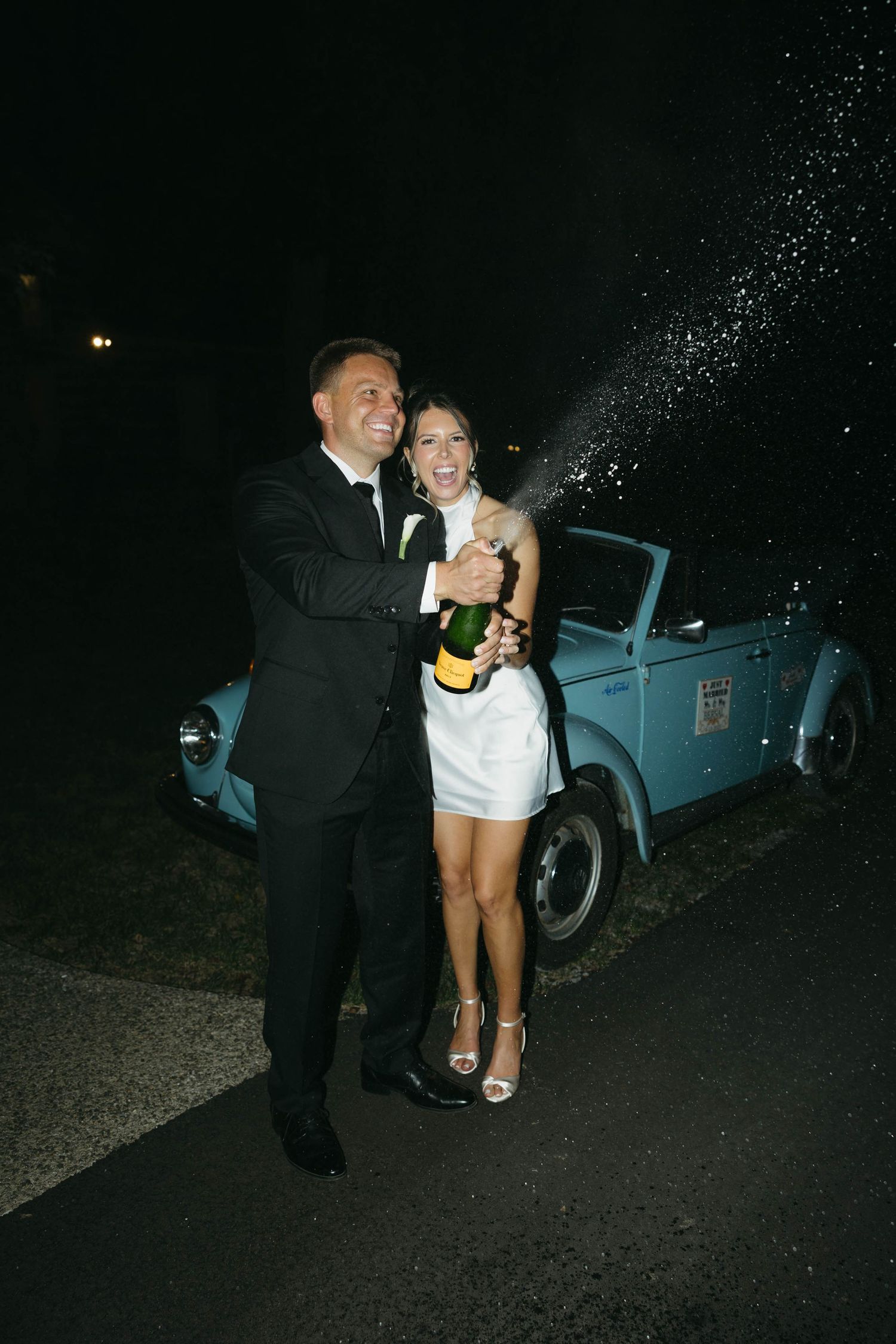 Birmingham Alabama Photographer capturing bride and groom popping champagne celebrating, at Iris Woods Venue in Nashville, Tennessee