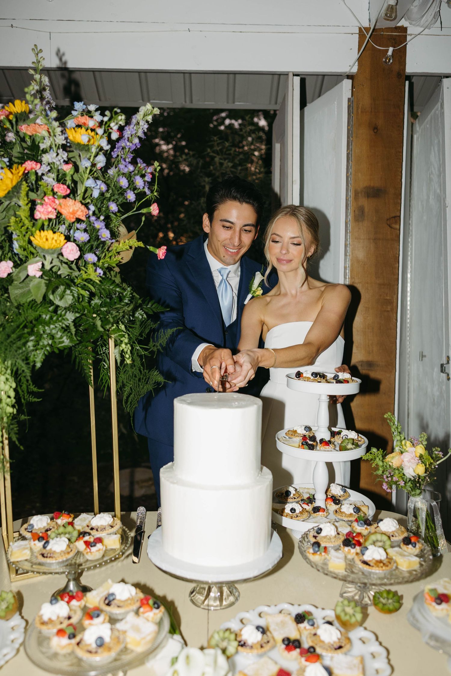 Birmingham Alabama Photographer capturing Bride and groom cutting their cake, at iris woods wedding venue in Nashville Tennessee