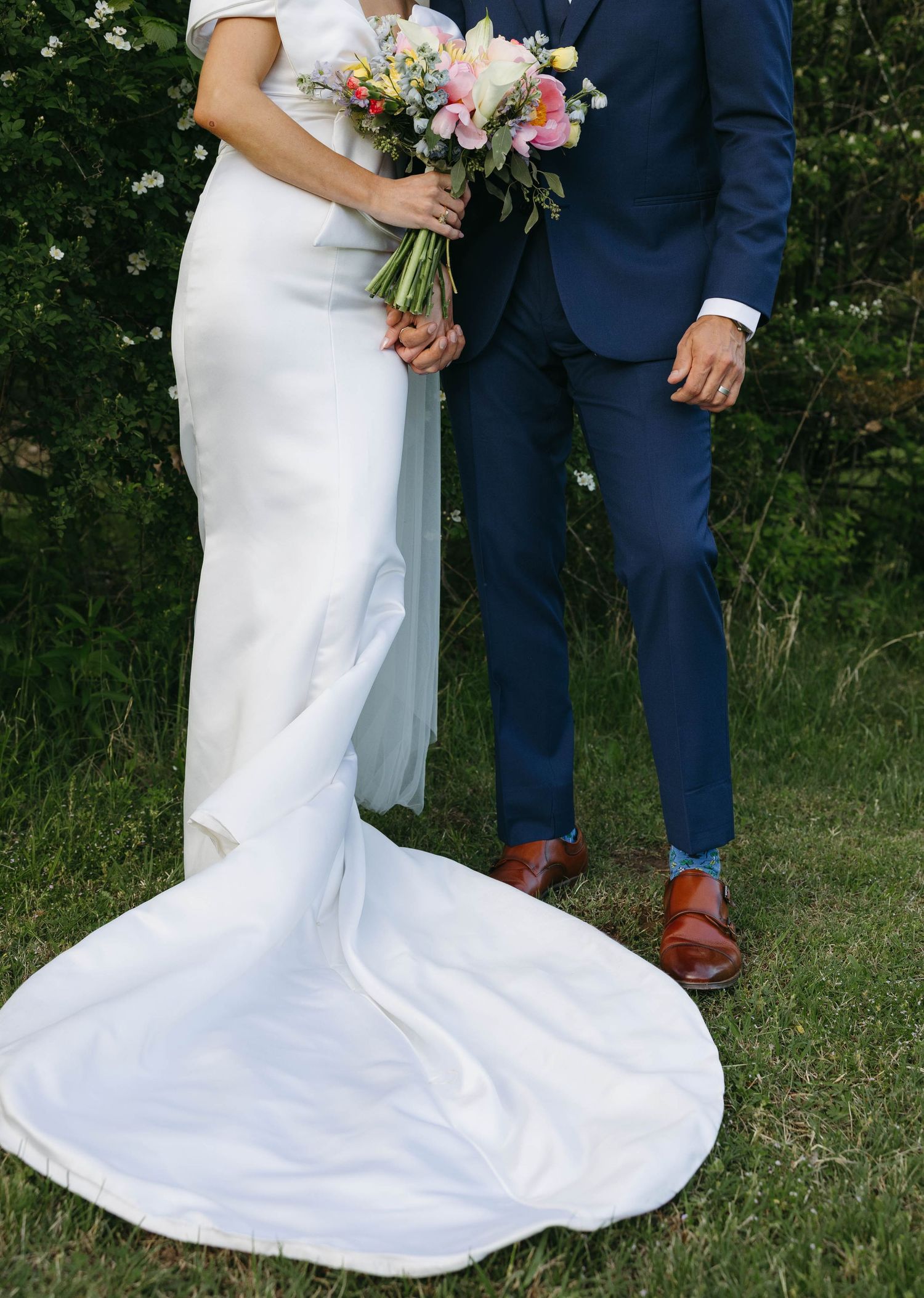 Birmingham Alabama Photographer capturing bride and groom posing holding hands, in a field, at Iris Woods Venue in Nashville, Tennessee