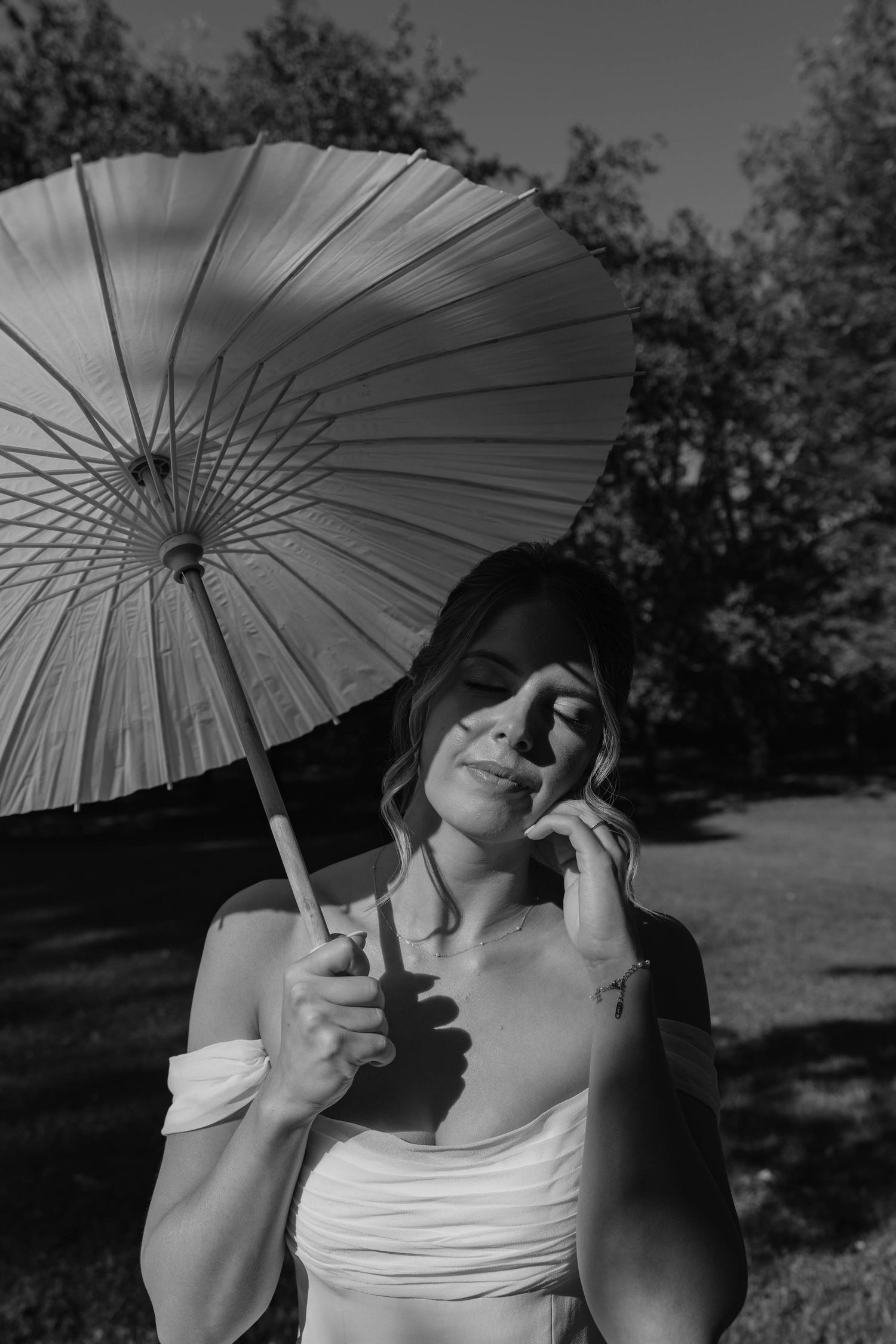 Birmingham Alabama Photographer capturing bride posing with her parasol, in the sun, at Iris Woods Venue in Nashville, Tennessee
