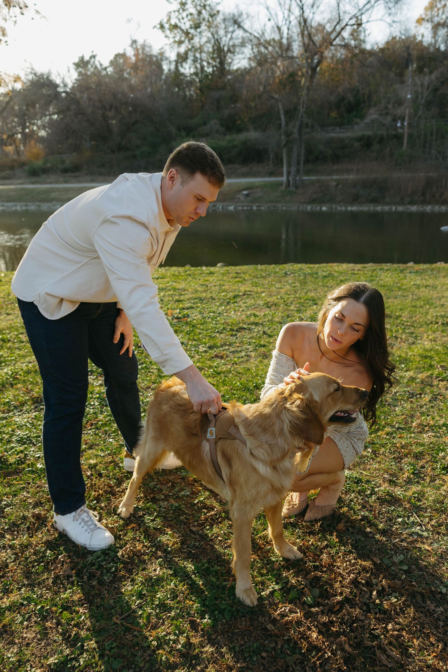 Birmingham Alabama Photographer capturing an engagement session of a couple playing with golden retriever in a park in Nashville Tennessee