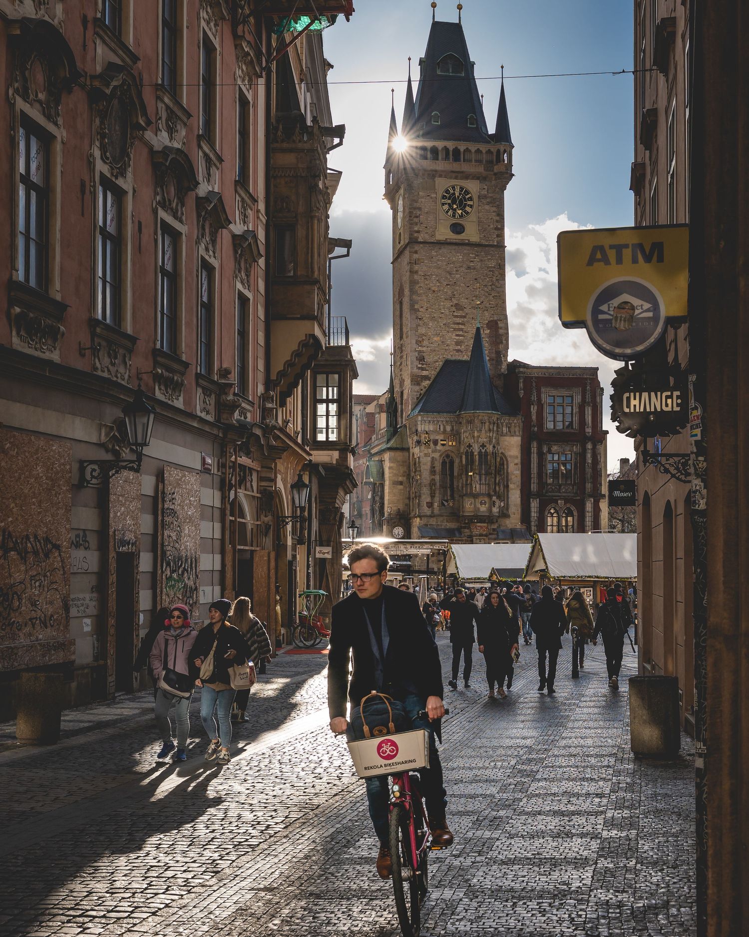 Reisefotografi – syklist i historisk gate med brostein og middelalderarkitektur