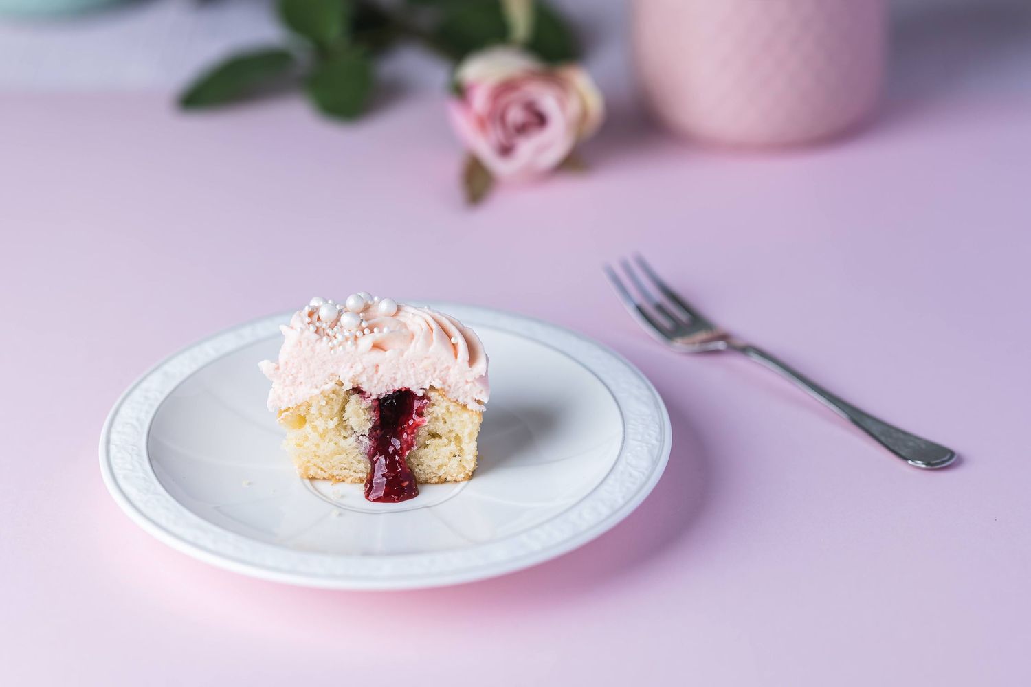 Kakefotografi – rosa lagkake med bær på pastellbakgrunn