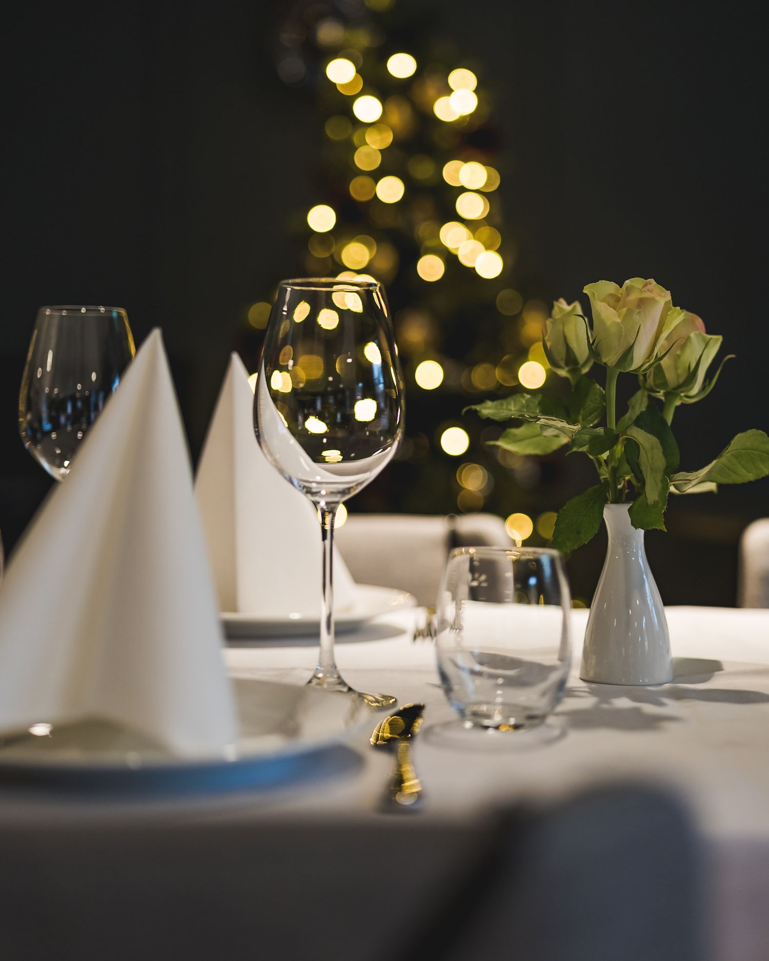 Borddekorasjon – elegant oppsett med vinglass, servietter og bokeh-lys