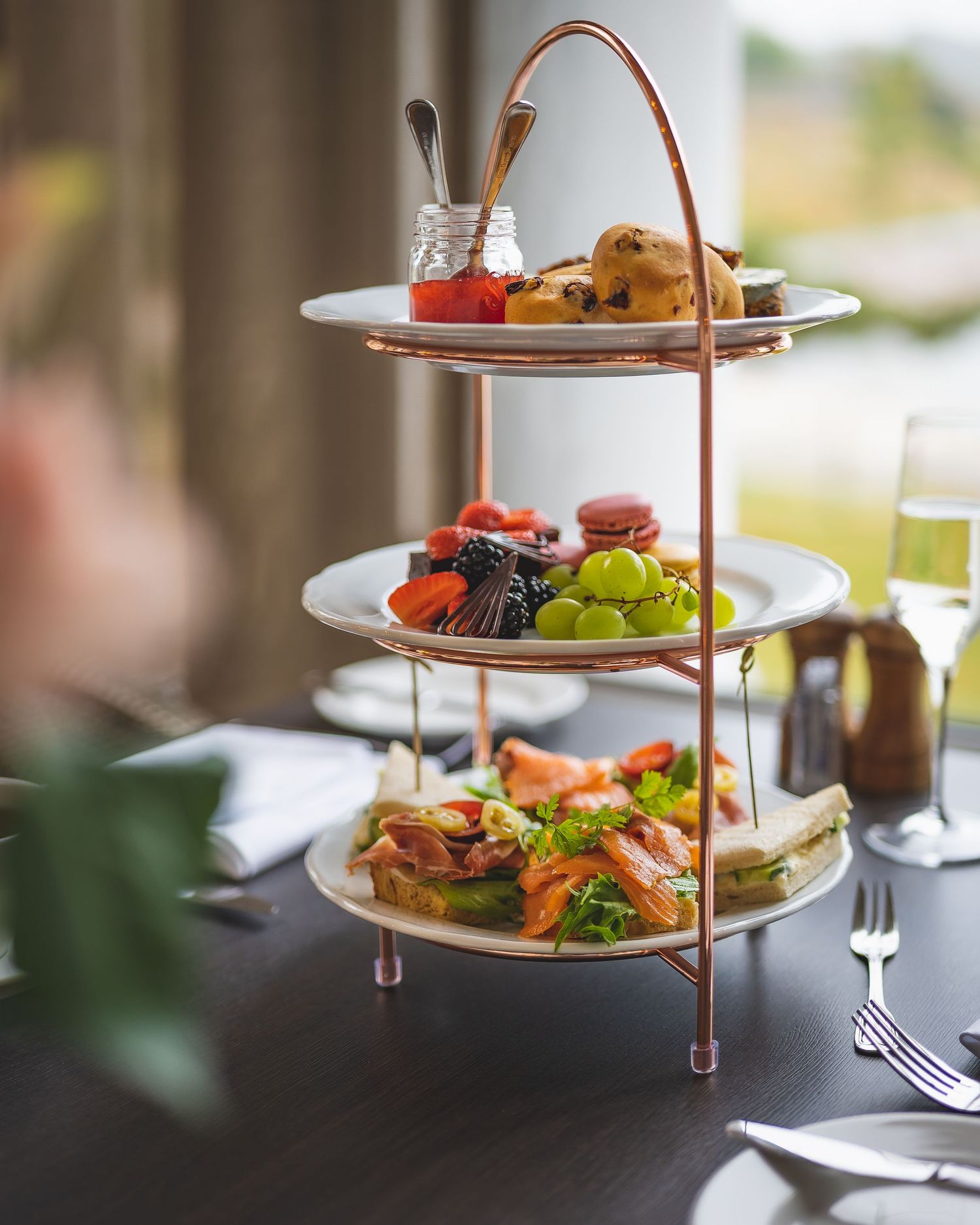 Matpresentasjon – etasjefat med frukt, sandwicher og småkaker til afternoon tea