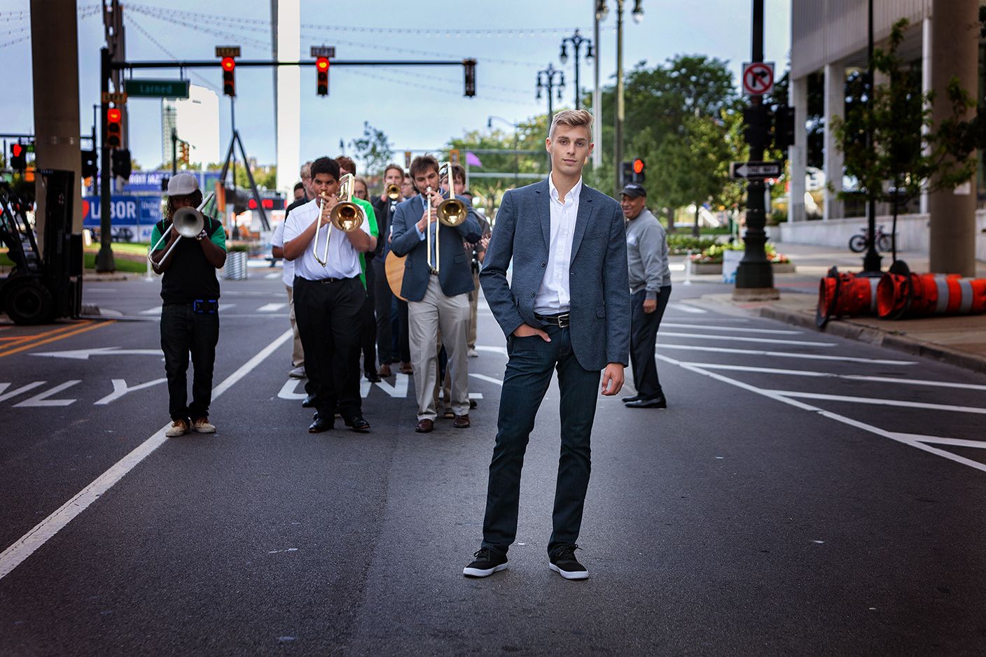 High school senior portrait in Rochester, MI by Jocelyn M. Photography—young man in blazer standing at a city intersection.