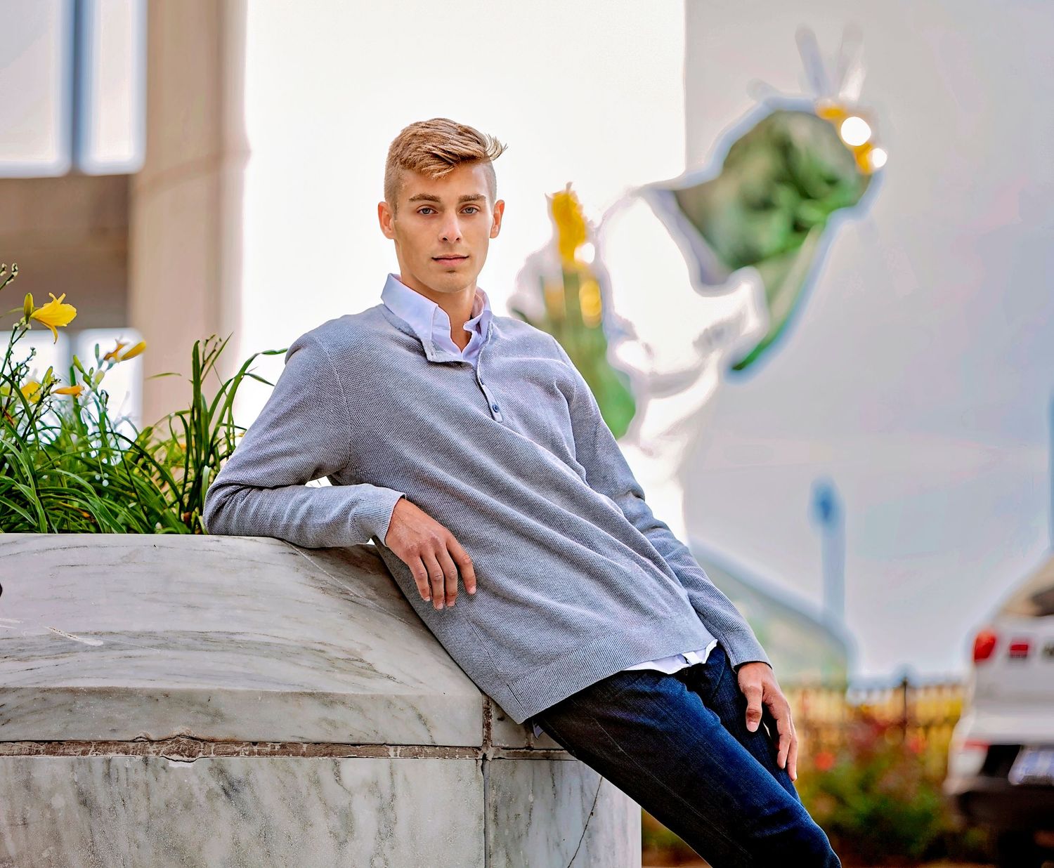 Senior portrait for guys in Rochester, MI by Jocelyn M. Photography—young man in gray shirt leaning on a stone wall.
