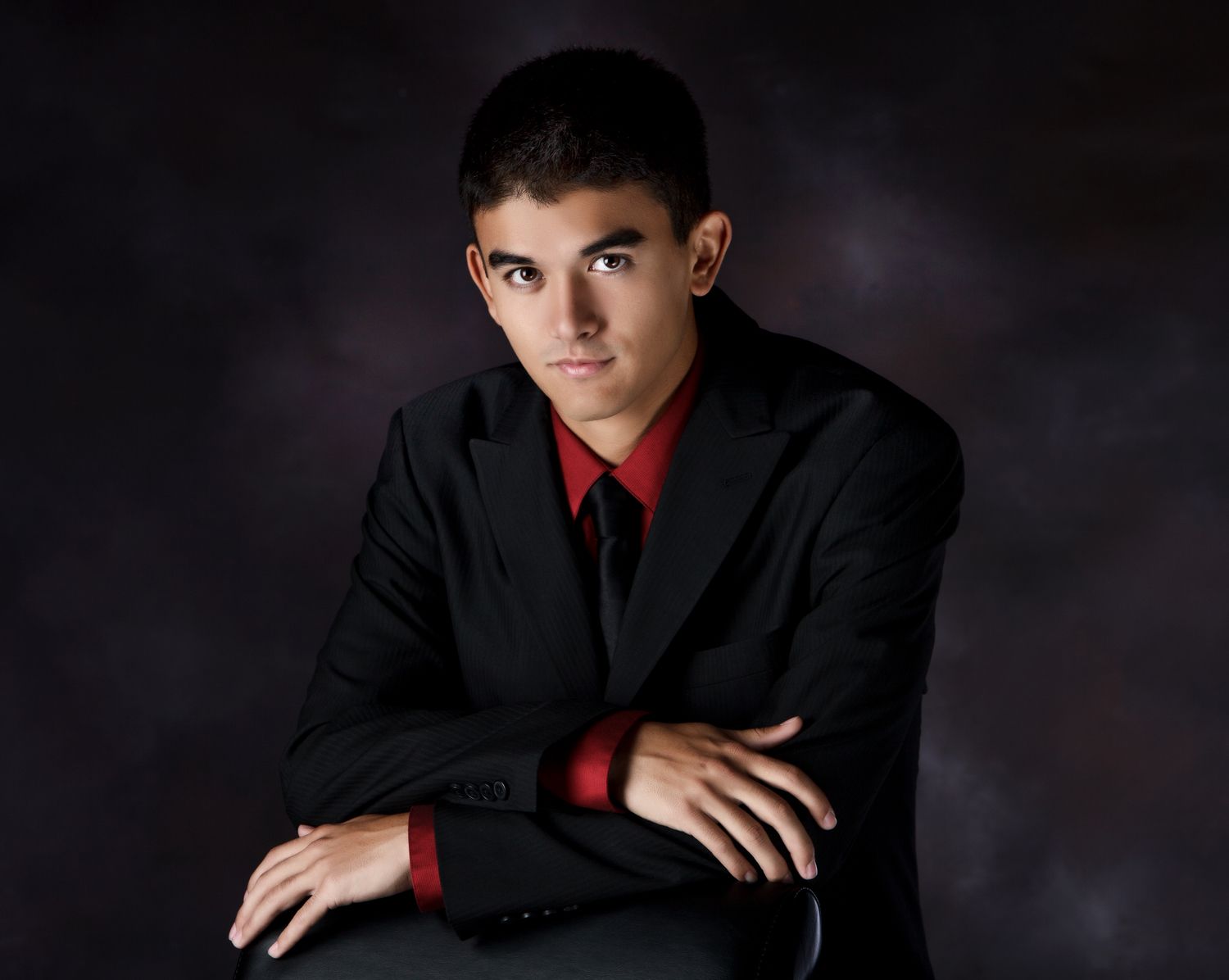 Studio senior portraits for guys in Rochester, MI by Jocelyn M. Photography—teen boy in a black suit and red shirt.