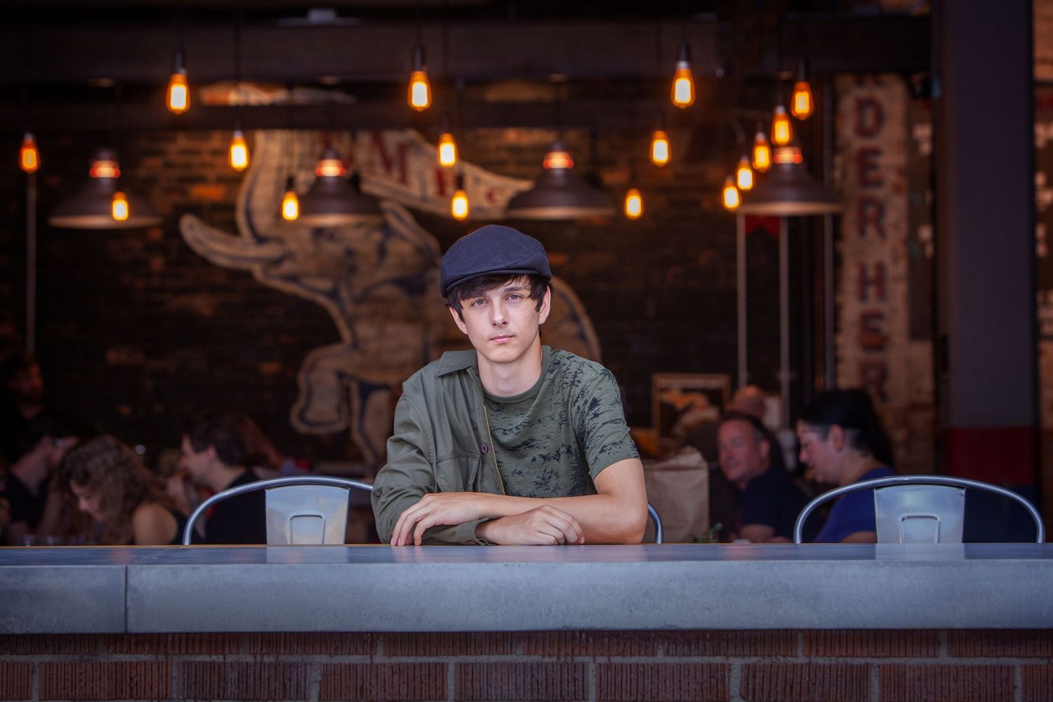 Creative senior portrait session in Rochester, MI by Jocelyn M. Photography—young man leaning on a diner counter.