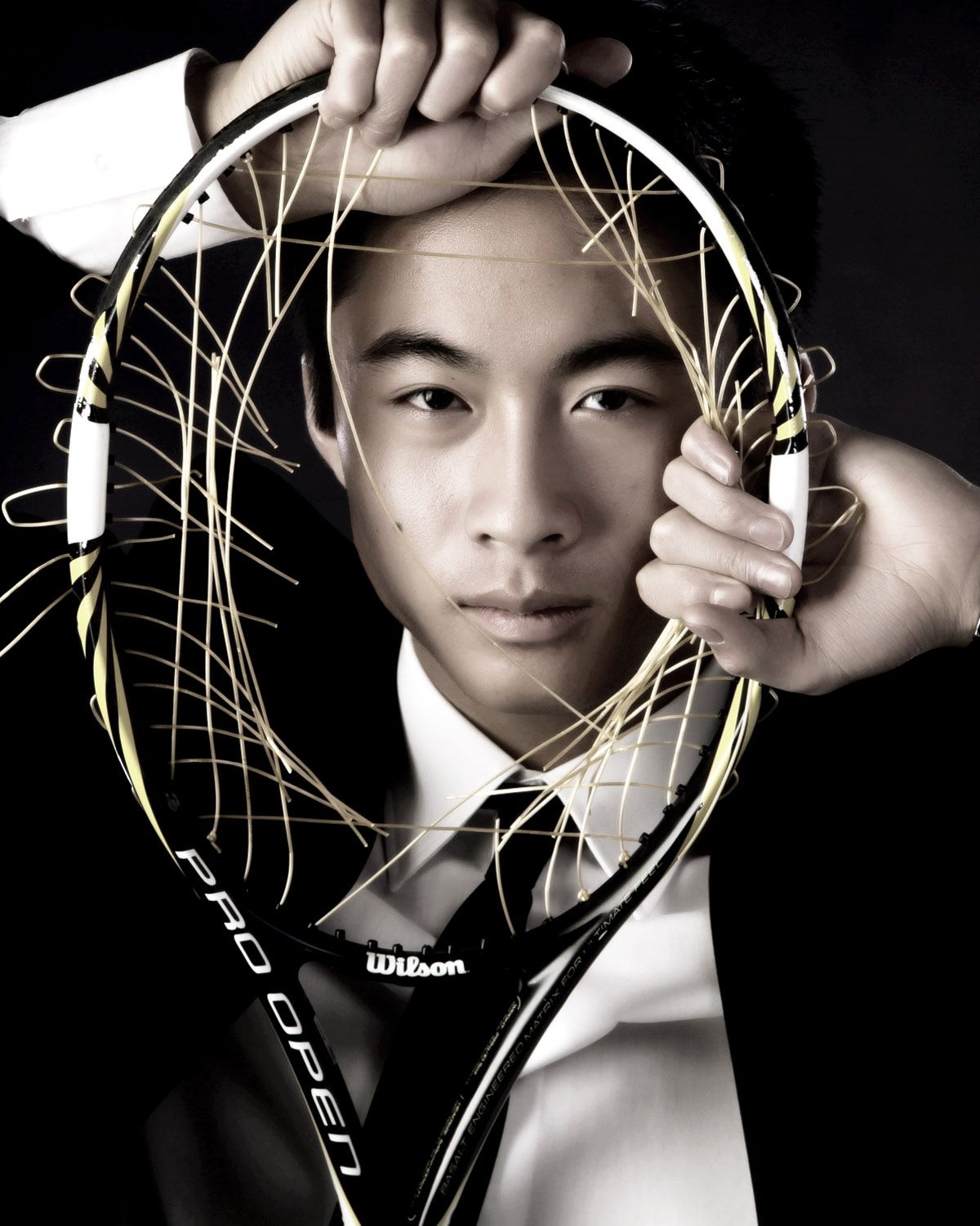 Senior portrait for athletes in Rochester, MI by Jocelyn M. Photography—black and white photo with a tennis racket.