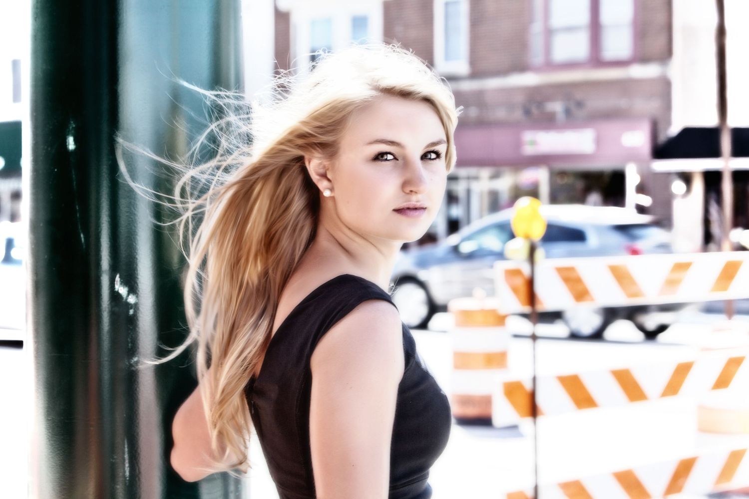 Senior girl by construction barriers in background, by Jocelyn M. Photography in Rochester, MI