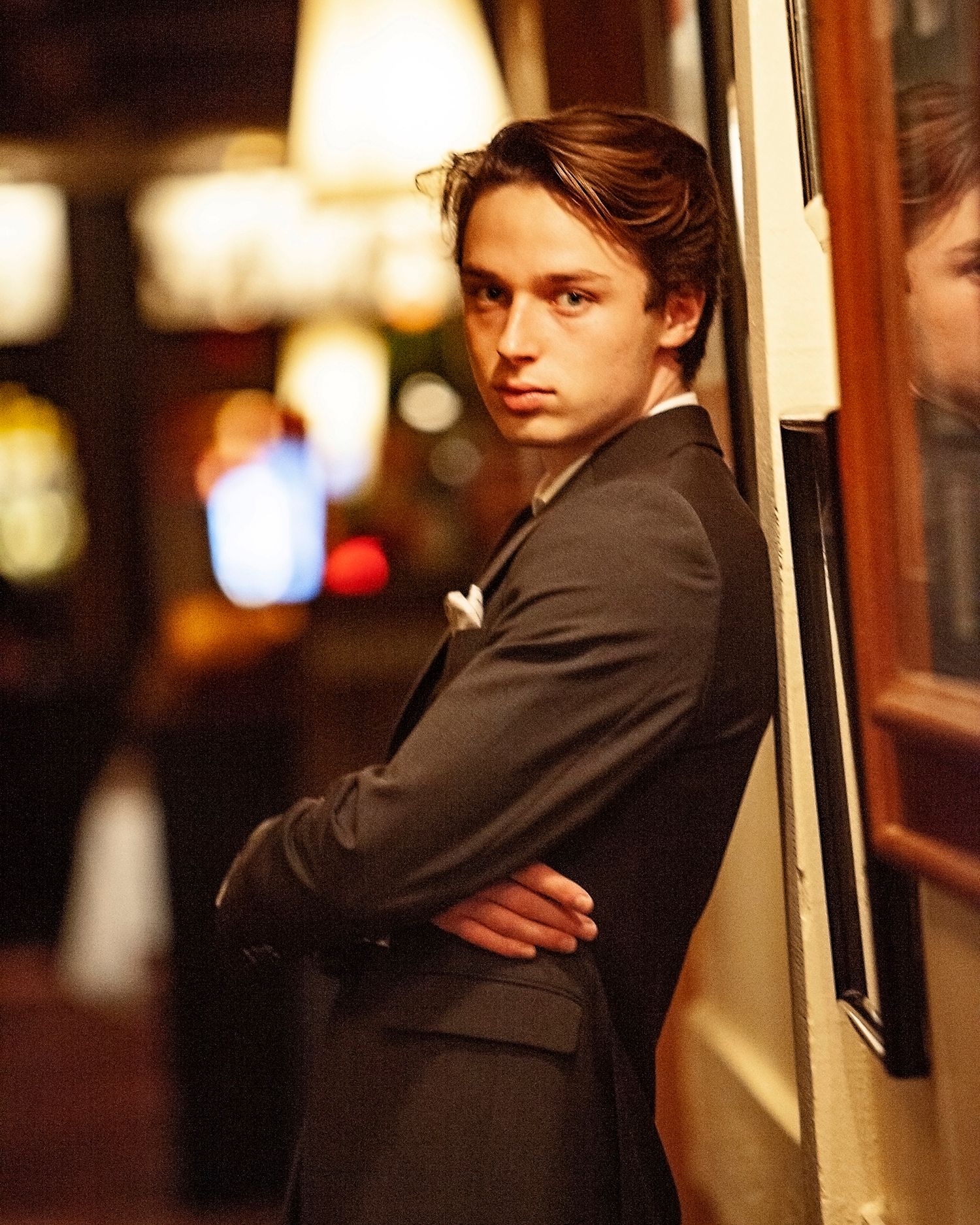 Moody senior portrait for guys in Rochester, MI by Jocelyn M. Photography—young man in dark suit in an urban setting.