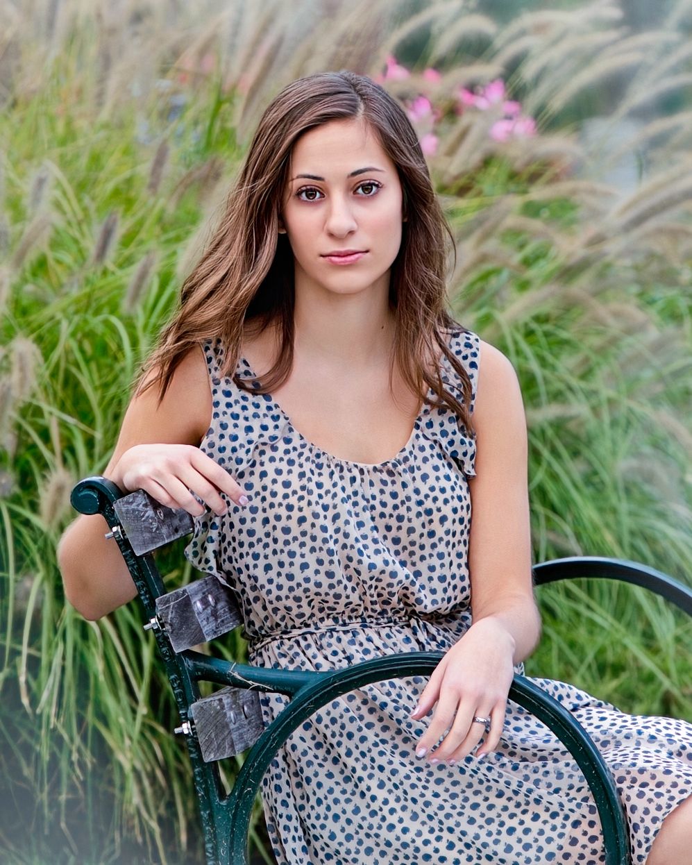 Senior girl portrait surrounded by tall ornamental grasses and pink flowers outdoors,by Jocelyn M. Photography in Rochester, MI .