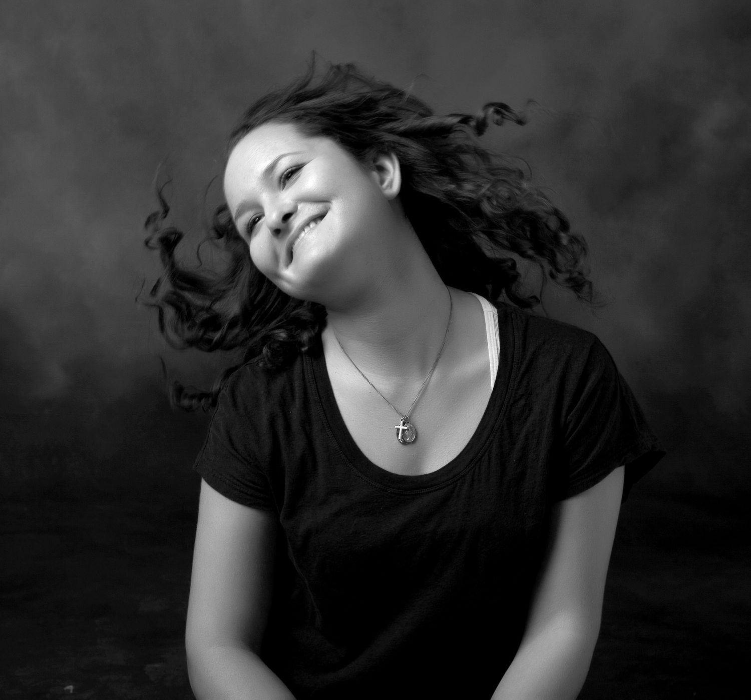 Senior girl portrait smiling joyfully with hair flowing in black and whiteby Jocelyn M. Photography in Rochester, MI