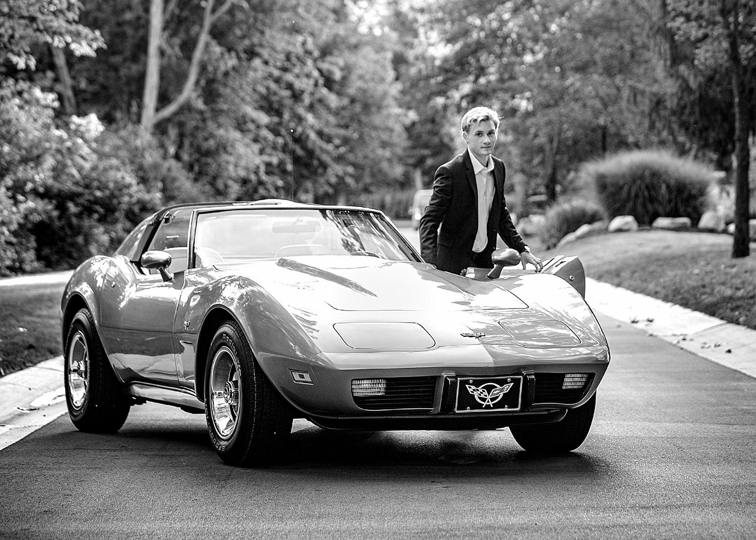 Senior portrait with a car in Rochester, MI by Jocelyn M. Photography—black and white photo with a classic Corvette.