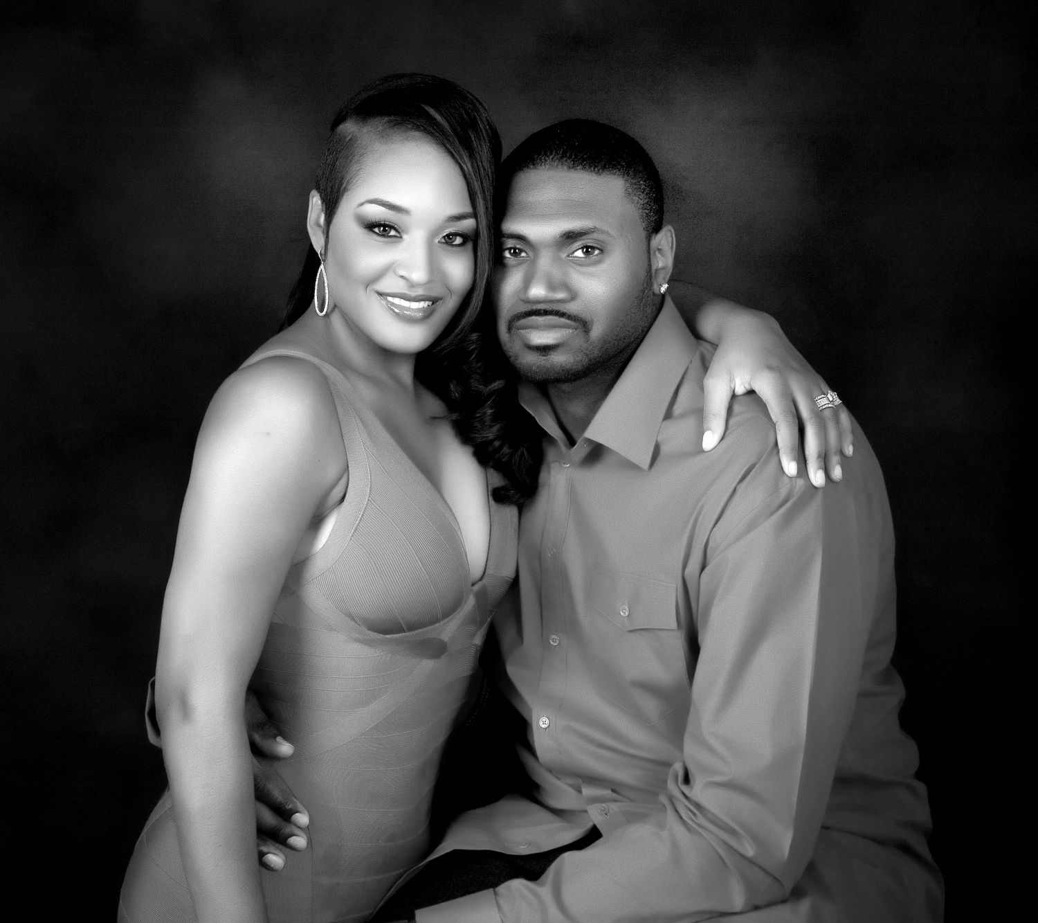 Black and white couples portrait of smiling man and woman in professional studio setting.