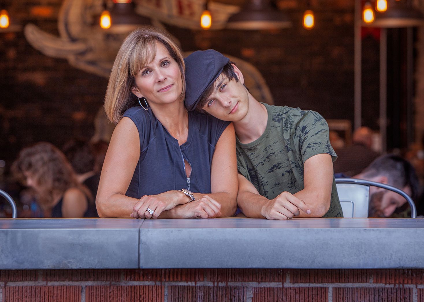 Senior portrait session in Rochester, MI by Jocelyn M. Photography—mother and high school senior son in cozy dining setting.