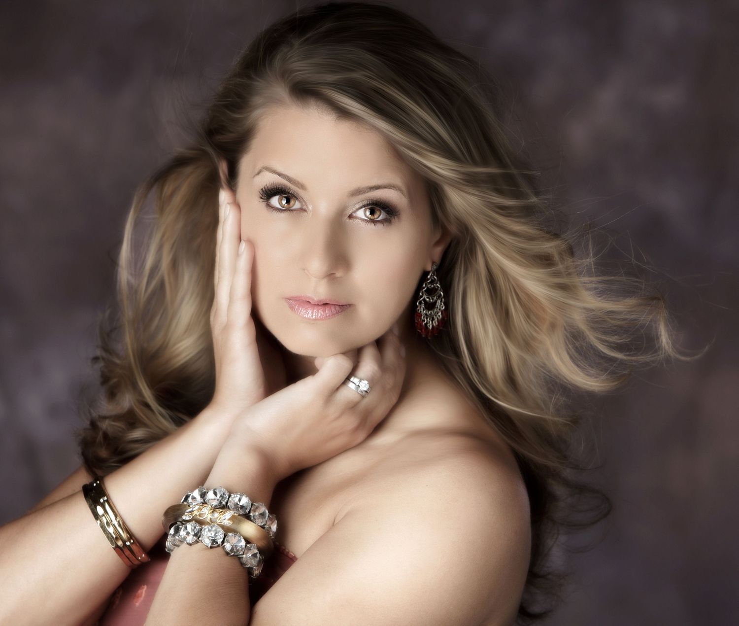 Woman with blonde hair wearing jewelry posing for a glamour portrait.