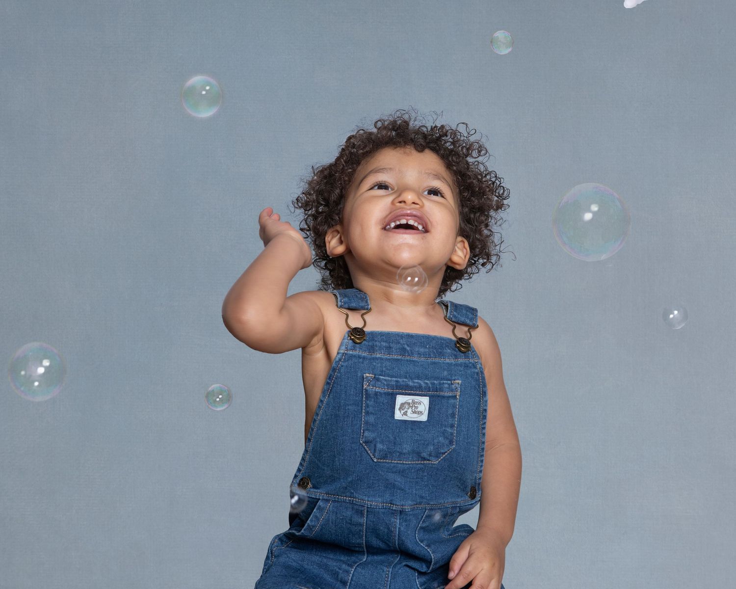 2-year-old child milestone session in Rochester, MI by Jocelyn M. Photography—joyful toddler in overalls with bubbles.