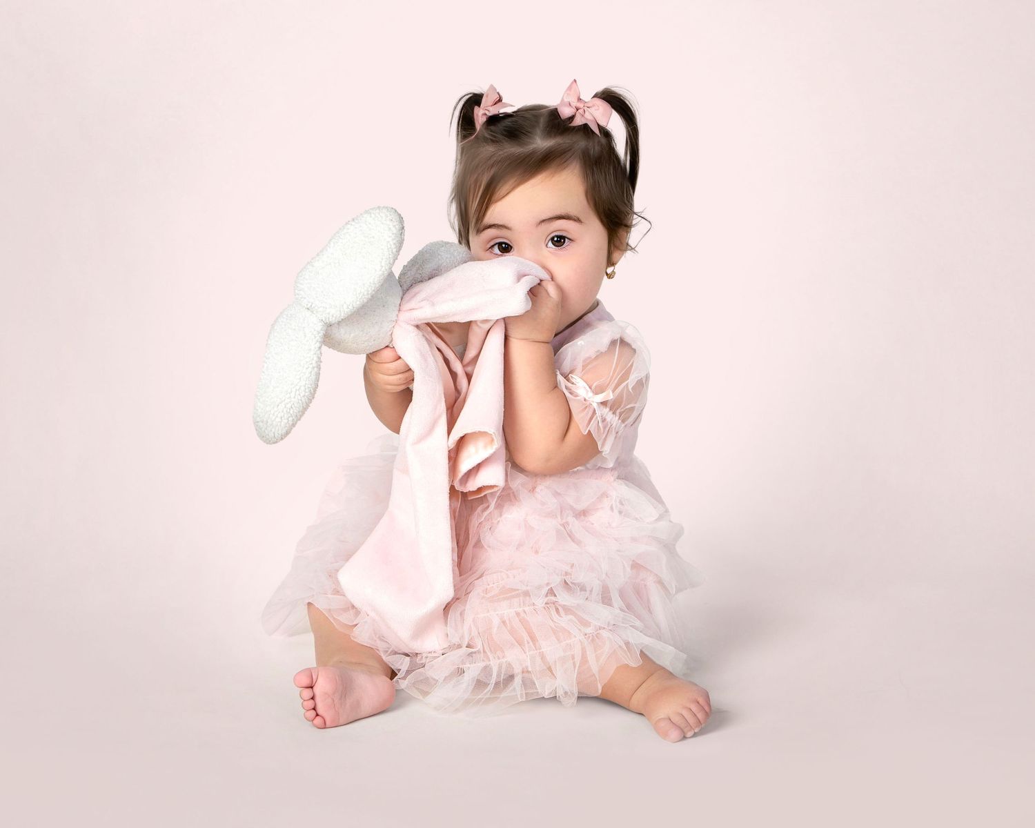 1st birthday child milestone portrait in Rochester, MI by Jocelyn M. Photography—toddler girl holding white stuffed bunny.