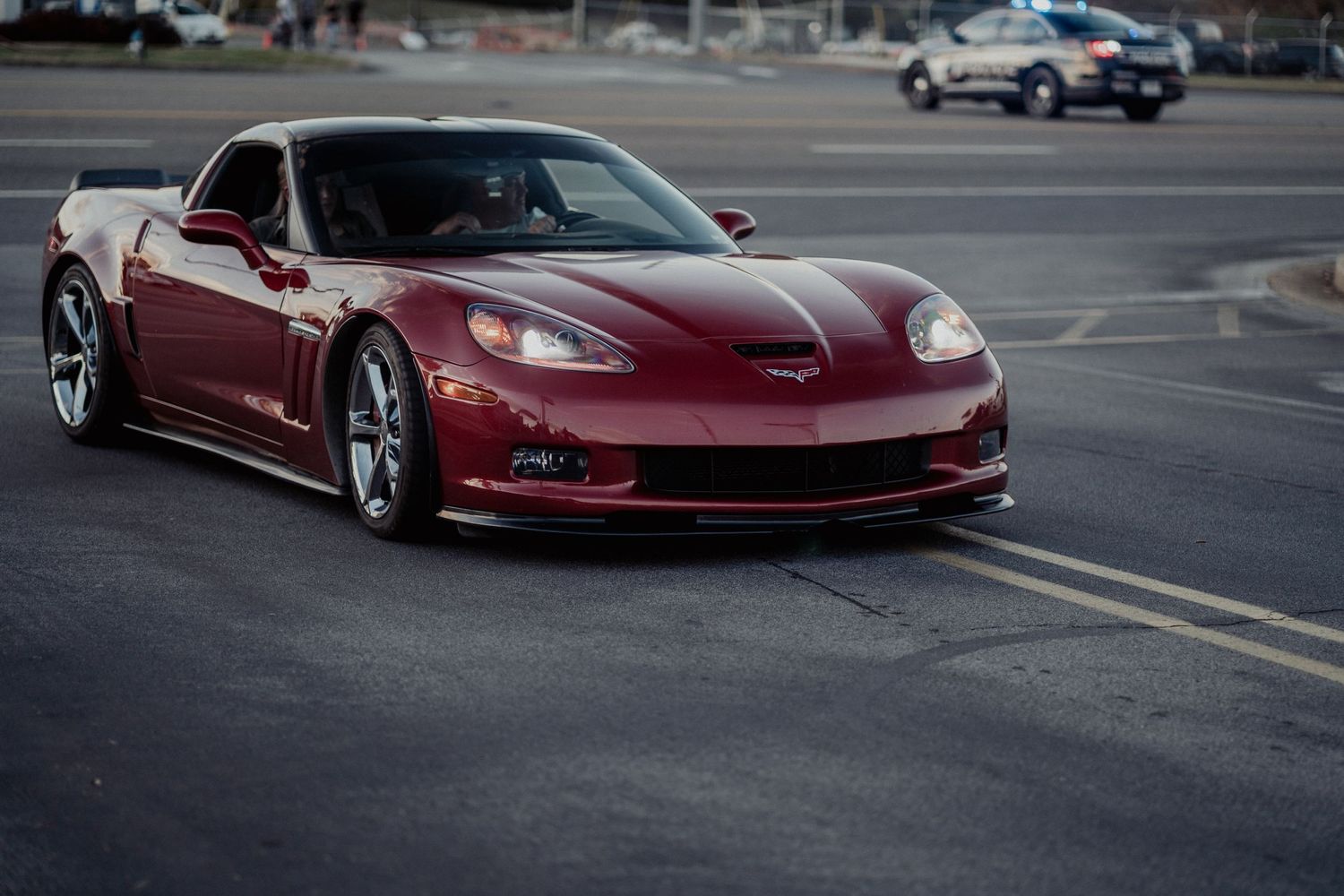 A maroon Chevrolet Corvette ZR1 with custom bodywork parked in an empty parking lot.