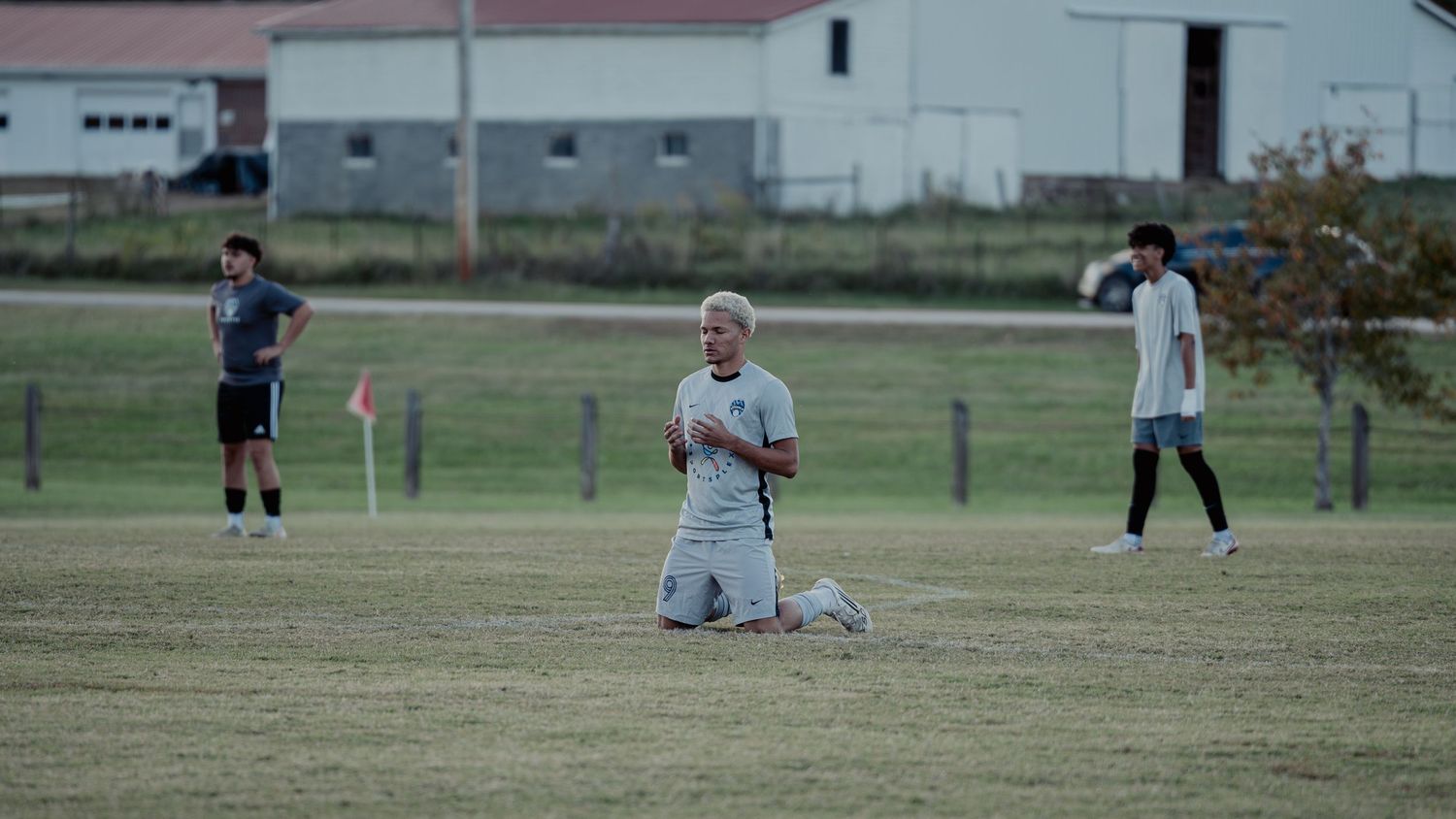 Soccer players stretch and warm up on a grassy field before practice or a game.