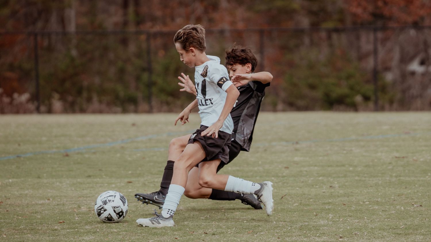 Soccer players compete for possession of the ball during an intense match on a grassy field.
