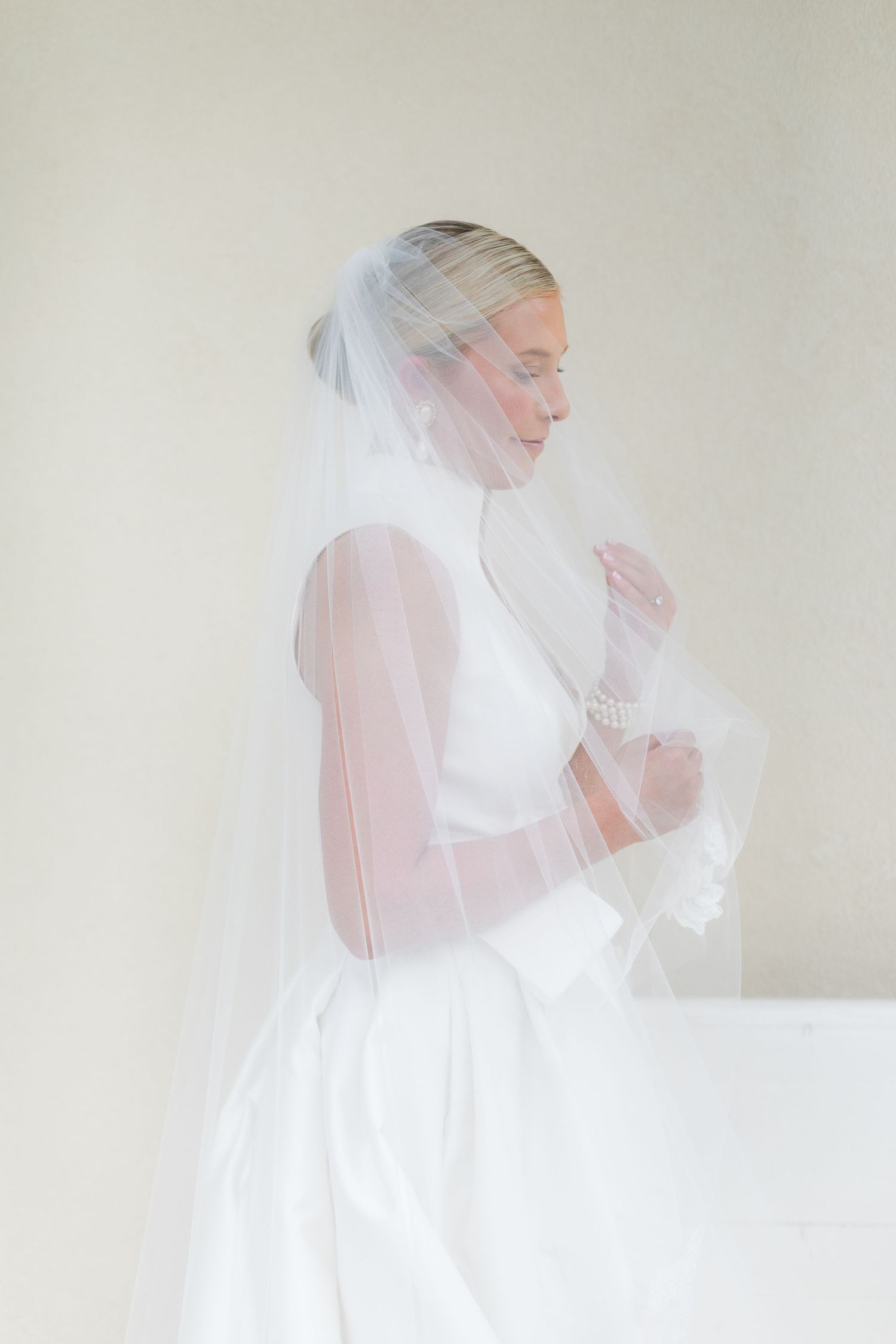 A series of ethereal bridal portraits showing a figure in a white wedding dress and veil against a light neutral background.