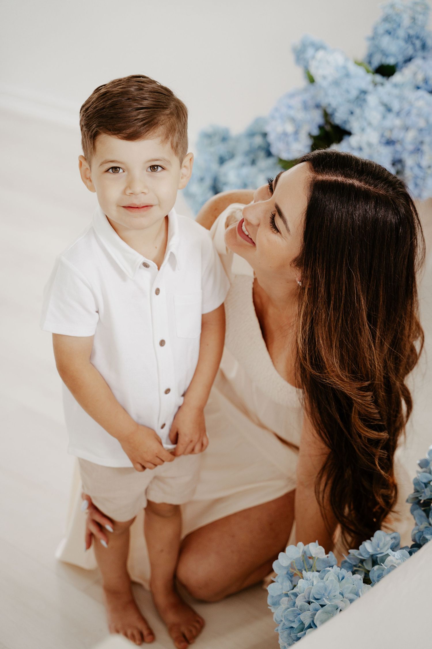 Son leaning into mother for a hug during sunset photo shoot