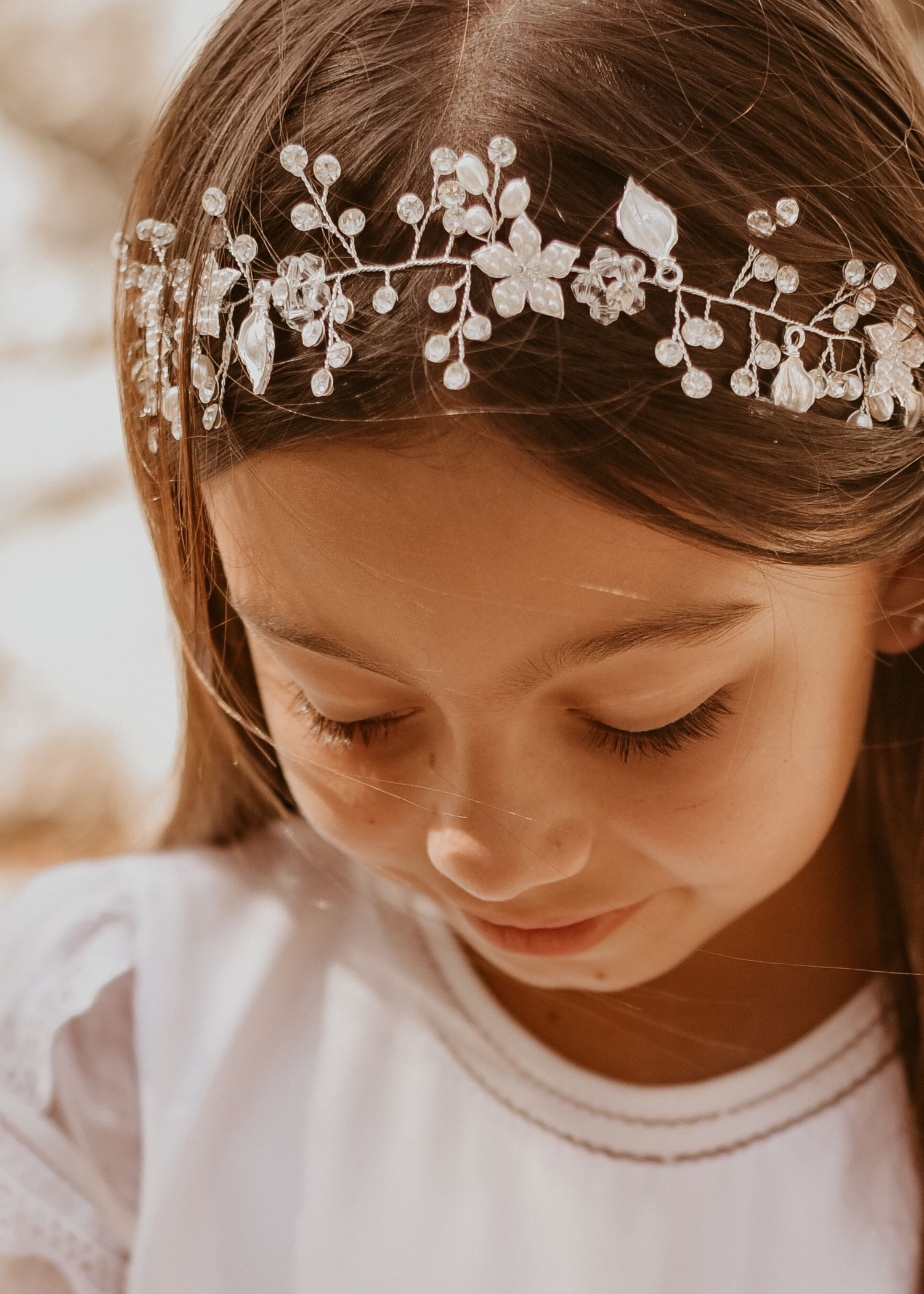Child in white dress holding rosary during First Communion portrait session