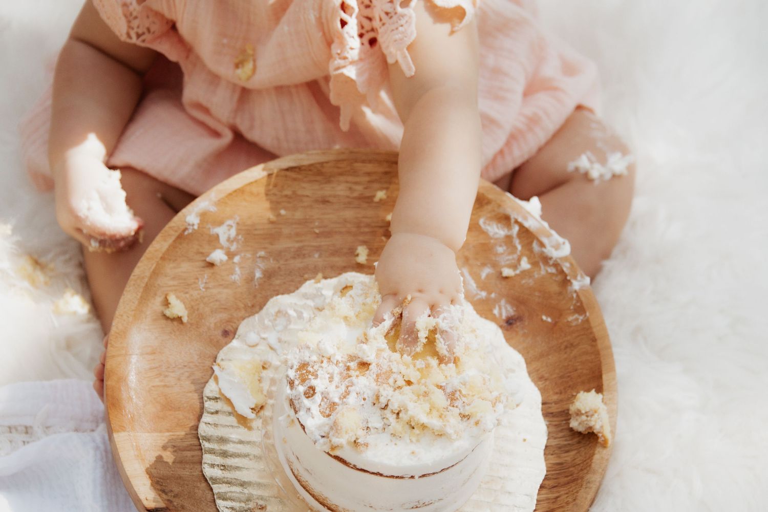 First birthday cake smash with soft pastel decor and joyful expressions