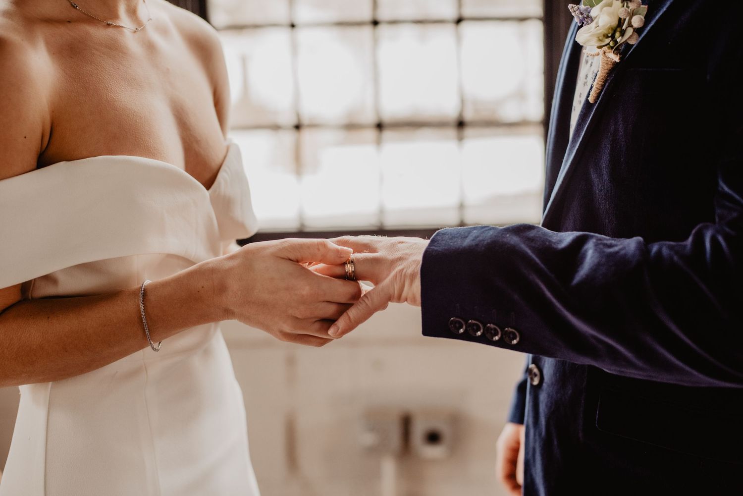 Romantic close-up of hands intertwined with engagement ring visible”