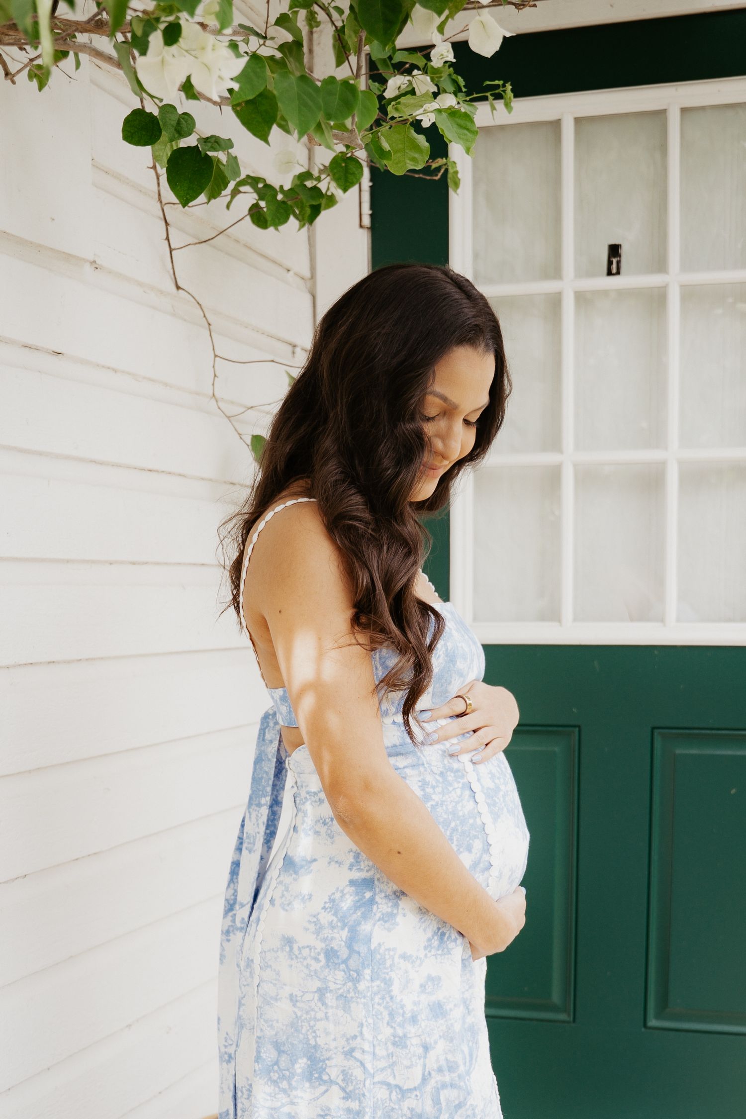 Pregnant mother standing in golden light during sunset maternity session