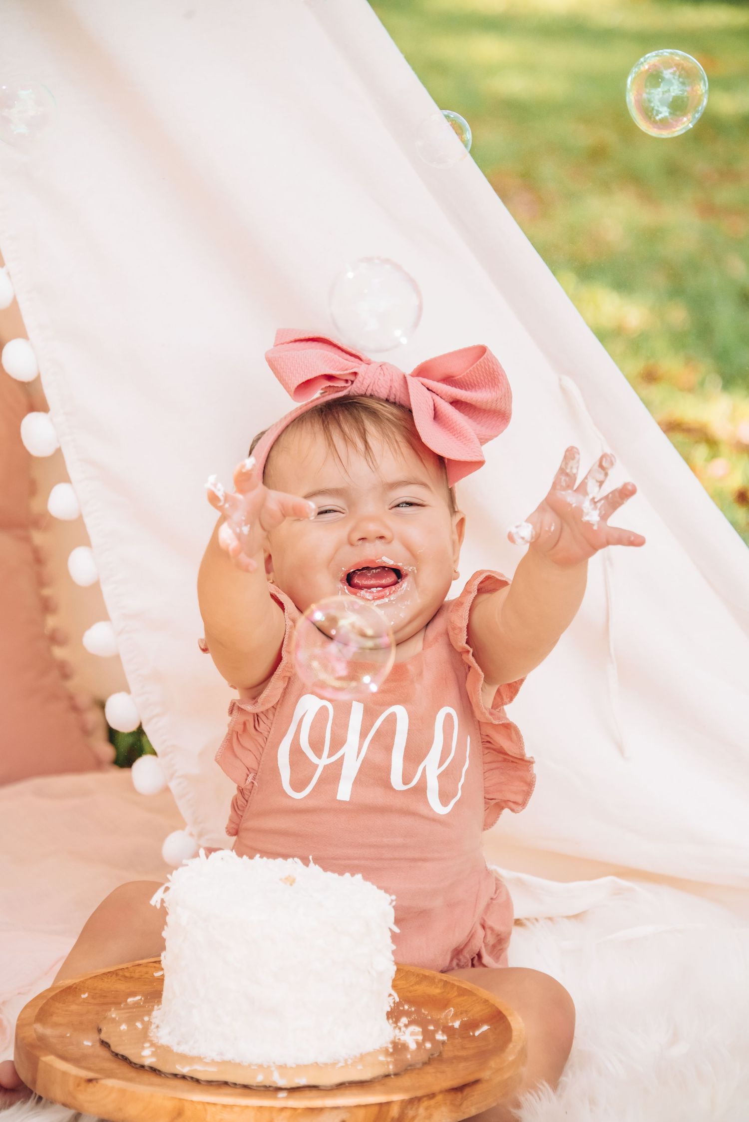 First milestone birthday cake smash with soft pastel decor and joyful expressions