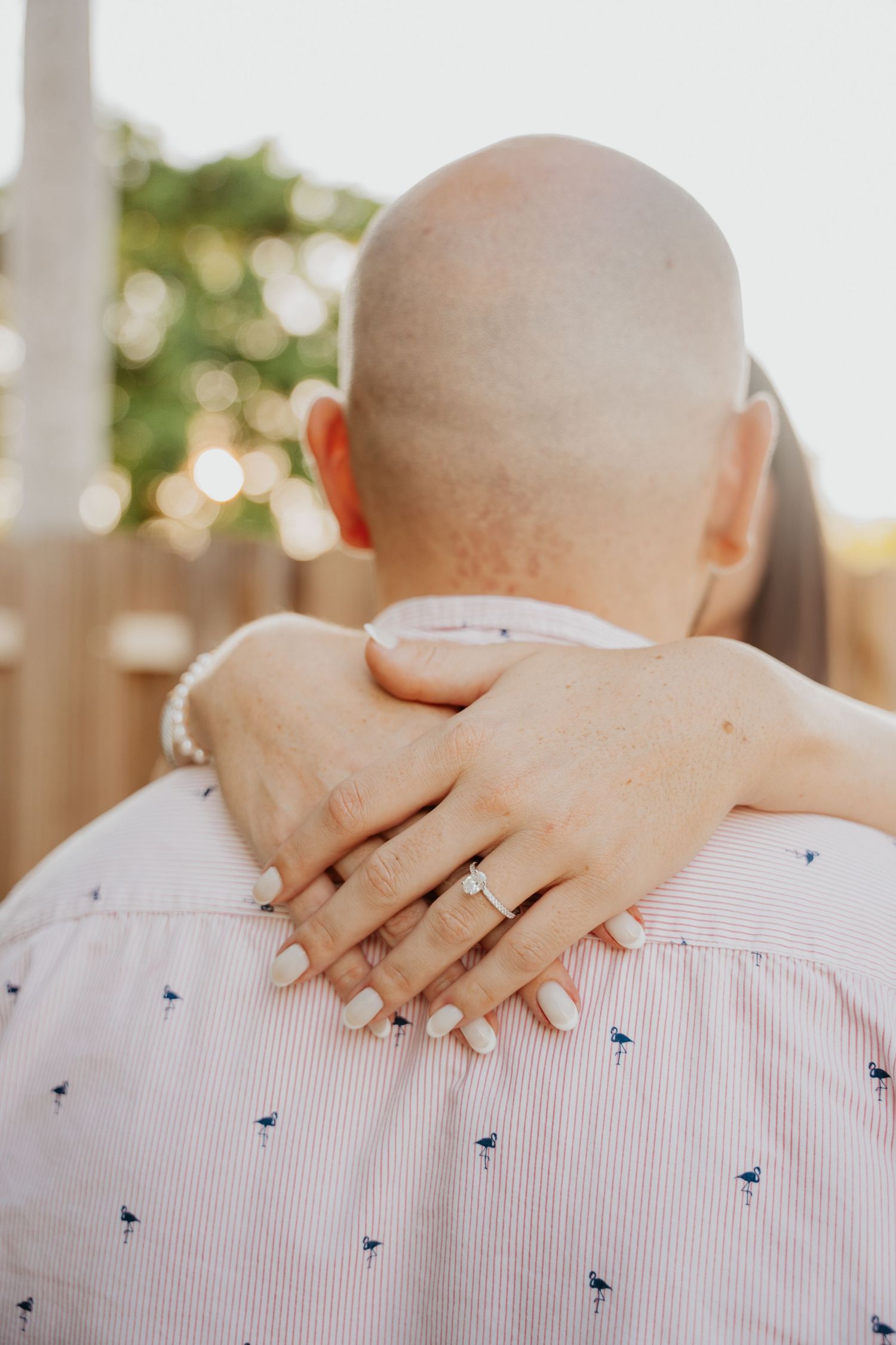 Close-up of couple’s hands with engagement ring in soft natural light