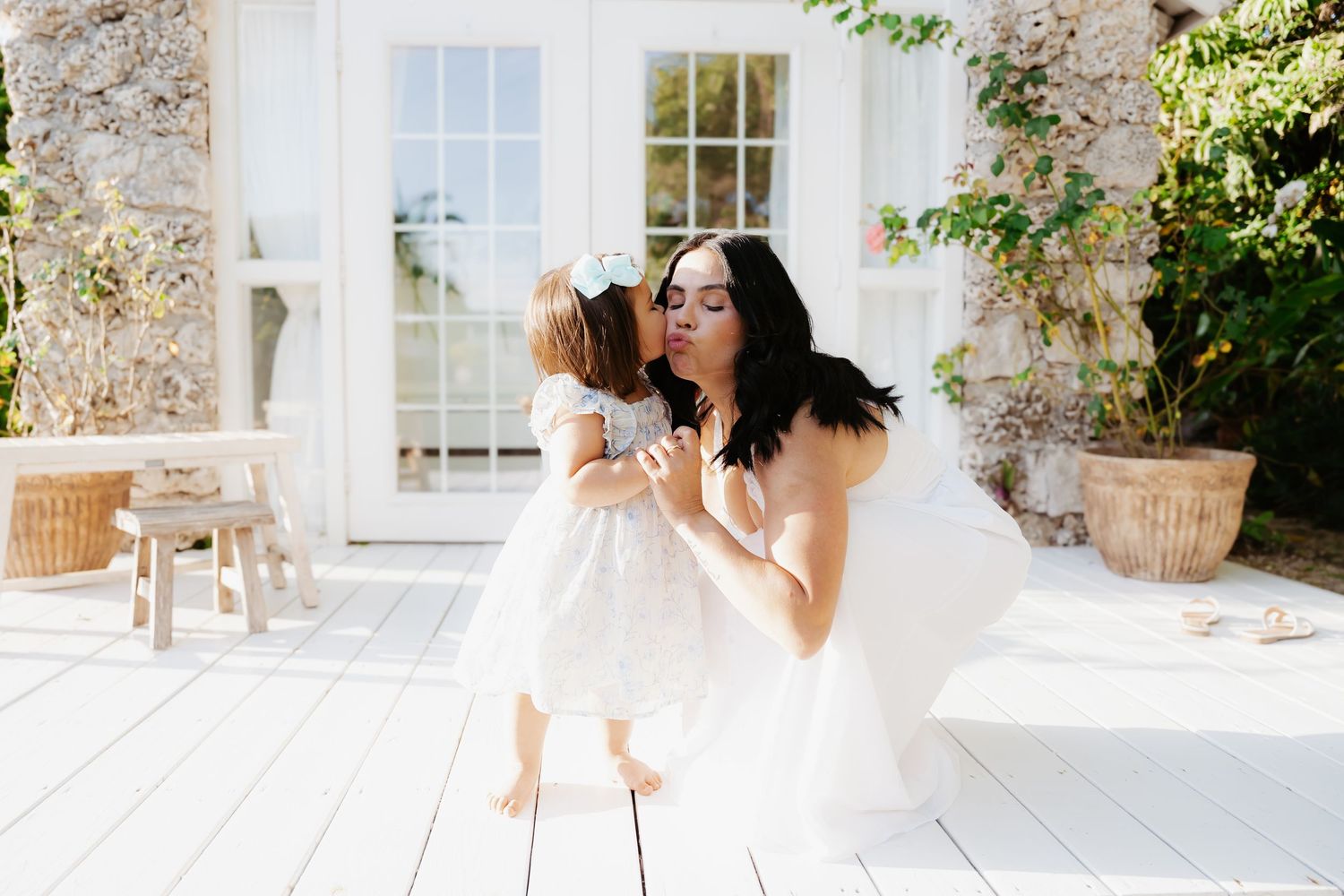 Candid outdoor moment of mother and toddler walking through garden