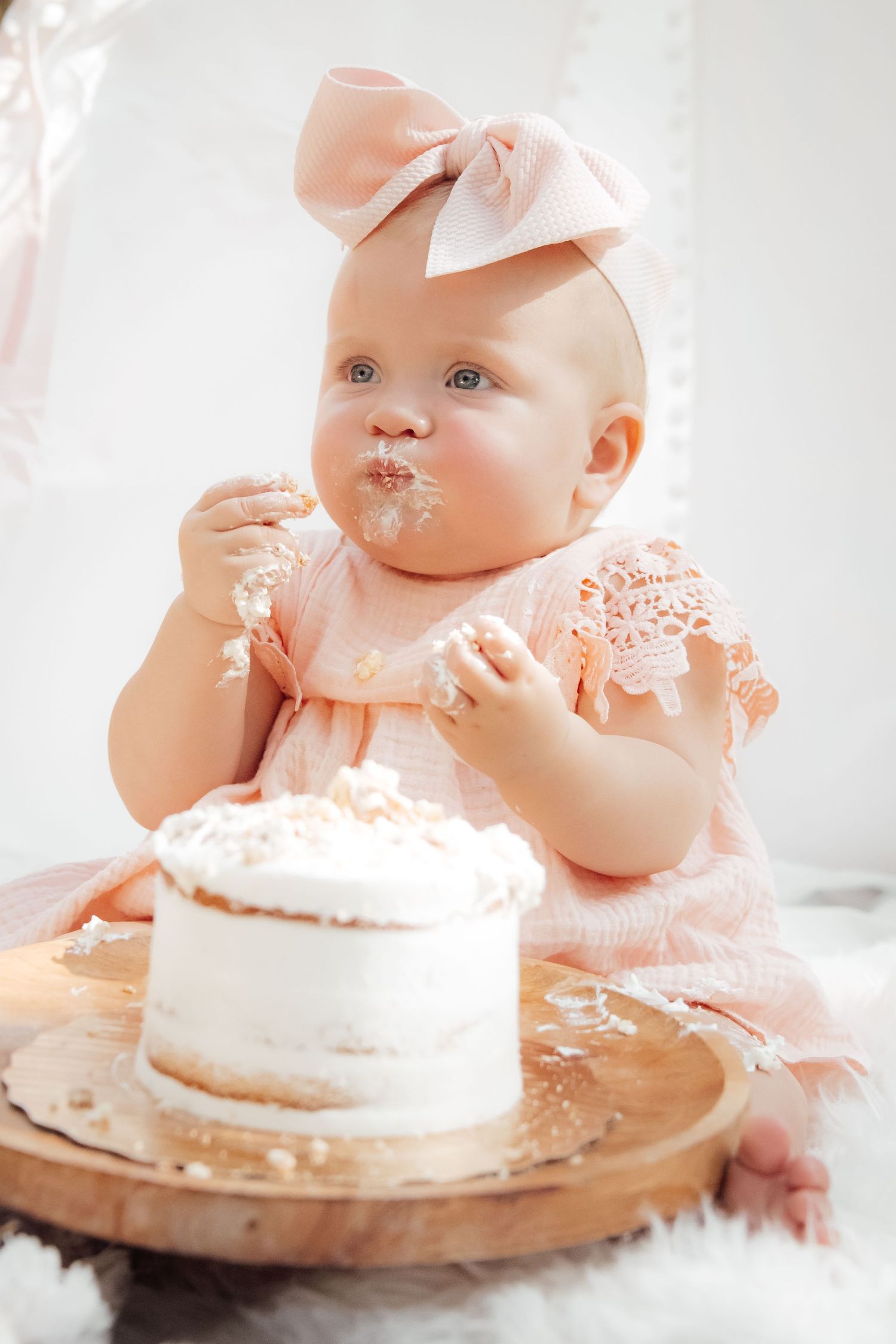 First birthday cake smash with soft pastel decor and joyful expressions