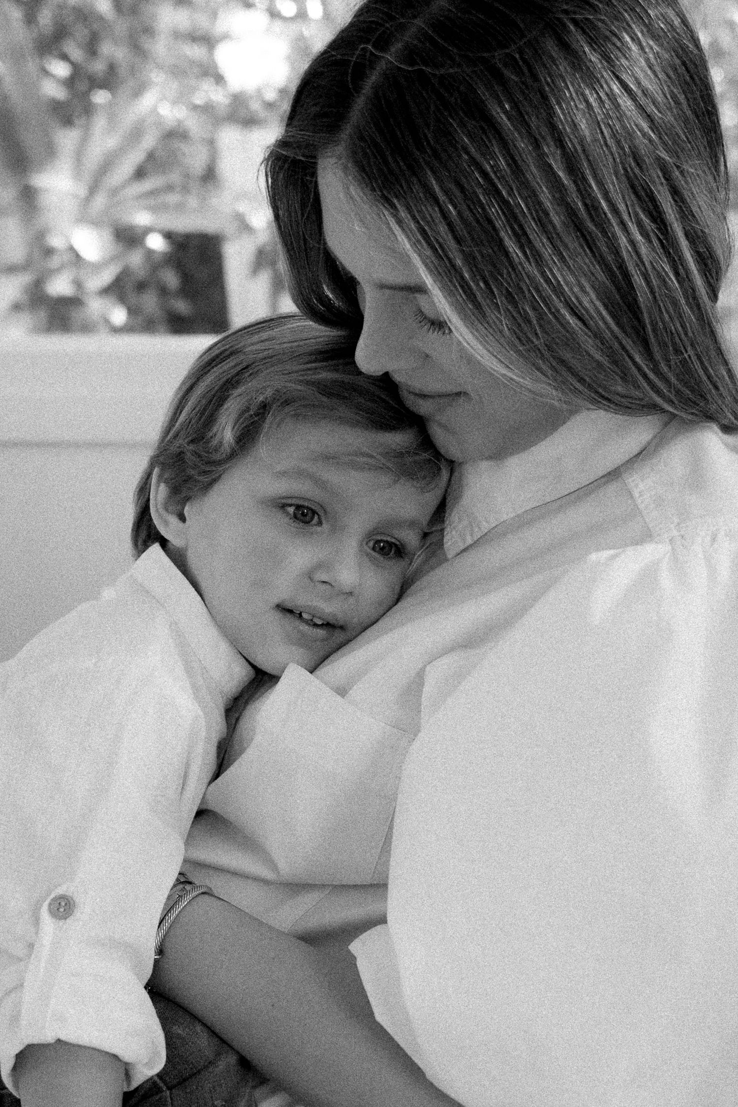 Editorial-style image of mother and son sitting together in the grass