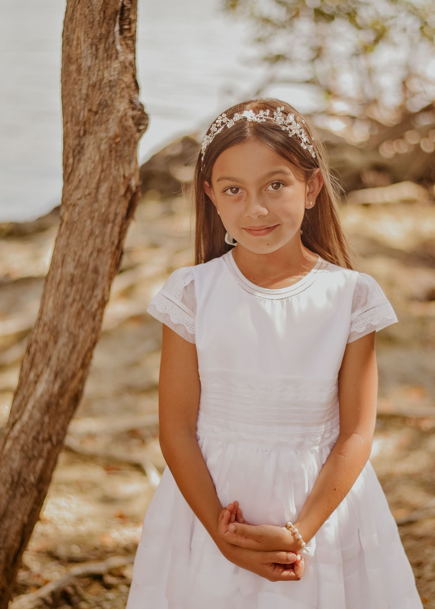 Child in white dress holding rosary during First Communion portrait session