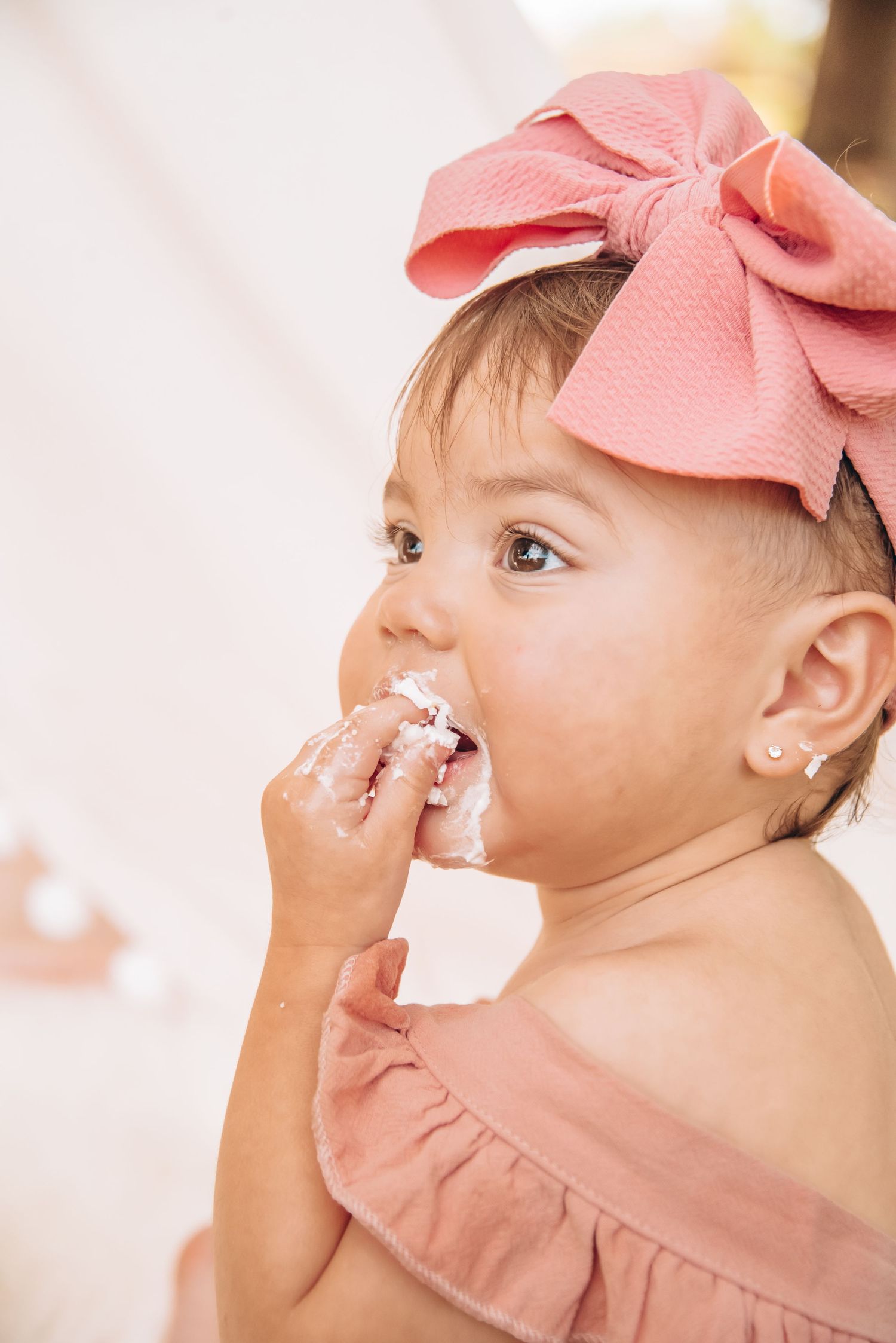 First birthday milestone cake smash with soft pastel decor and joyful expressions