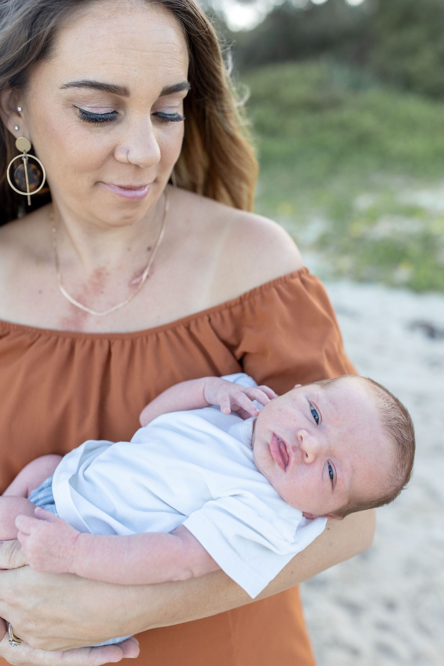 Lifestyle newborn photography at the beach, capturing gentle, coastal tones.