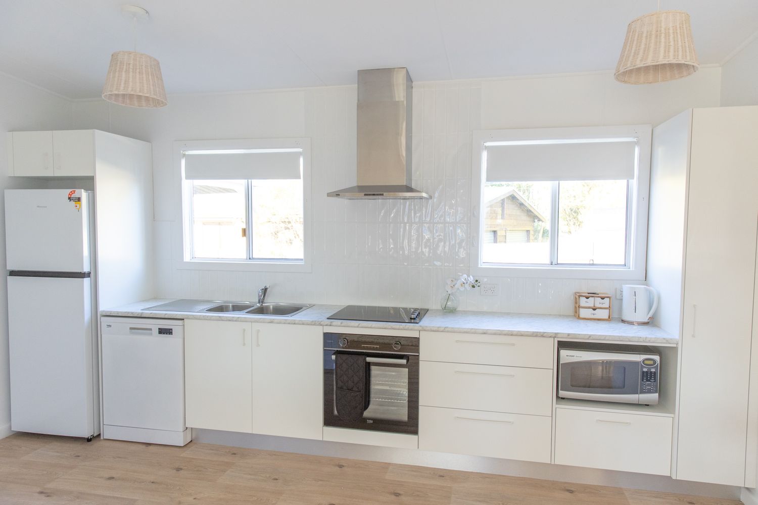 Clean white modern kitchen with appliances and minimalist design features.