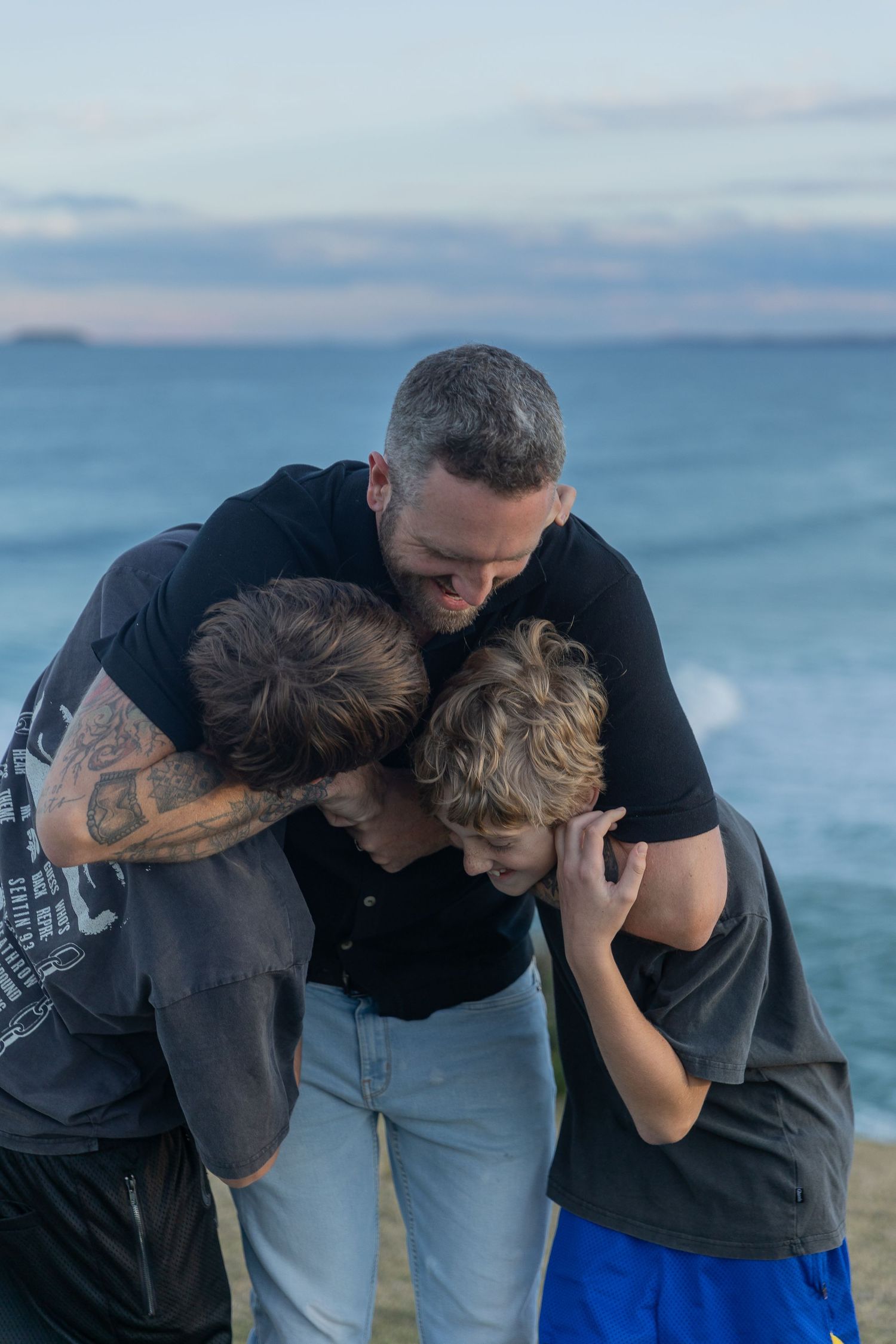 Family sharing an emotional moment together by the ocean.
