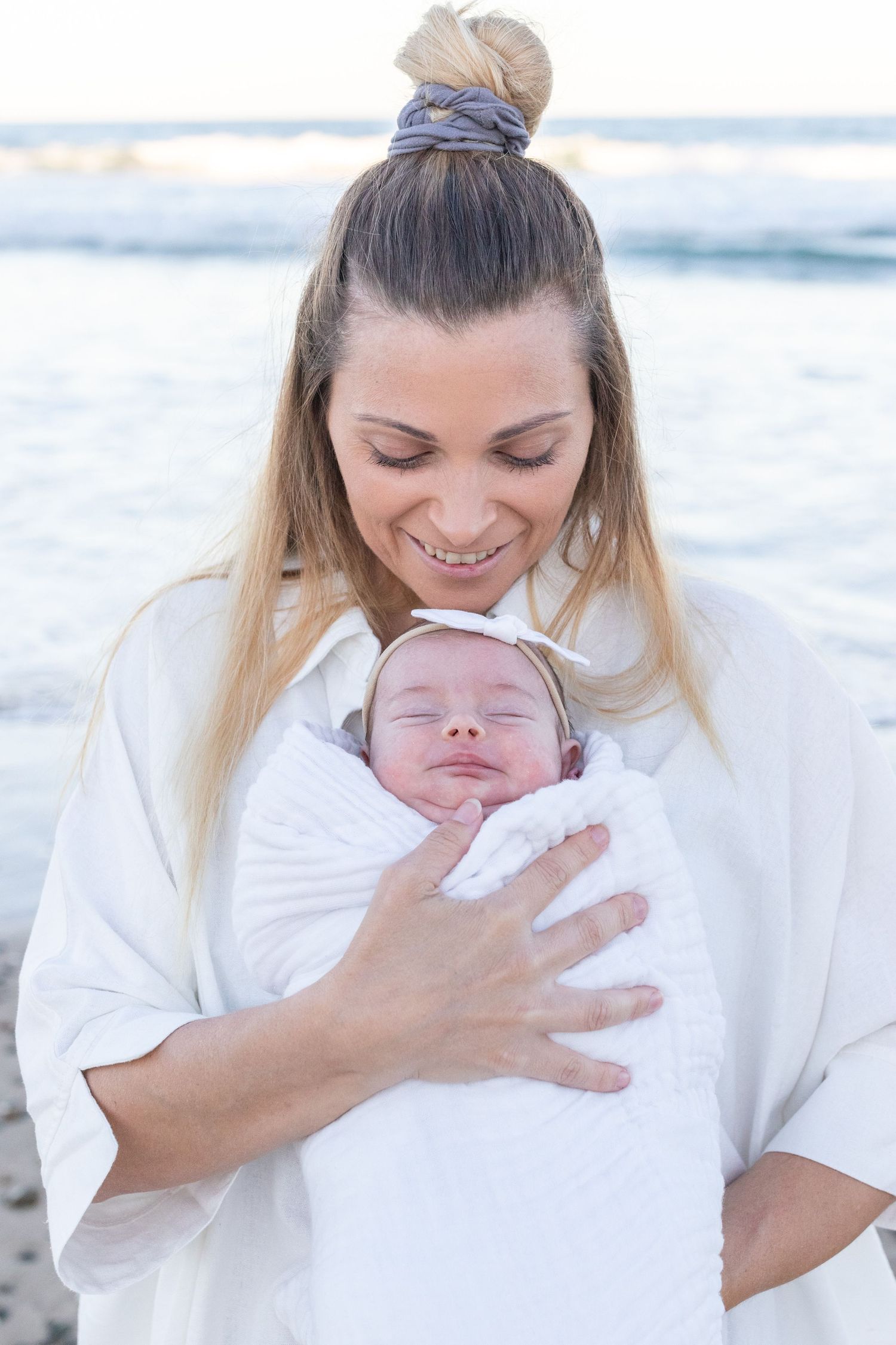 Lifestyle newborn photography at the beach, capturing gentle, coastal tones.