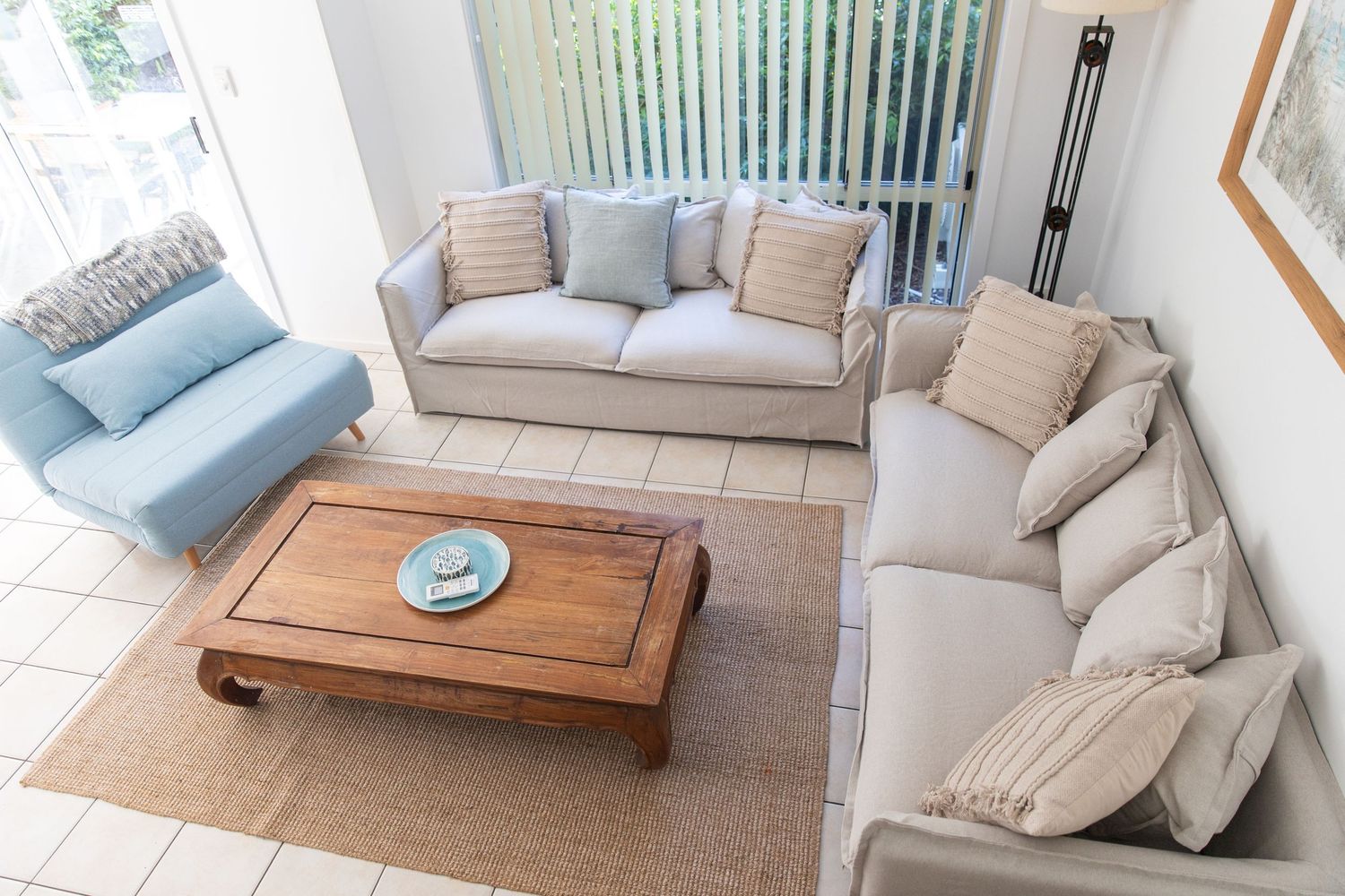 Modern living room featuring comfortable beige sectional and blue accent chair.