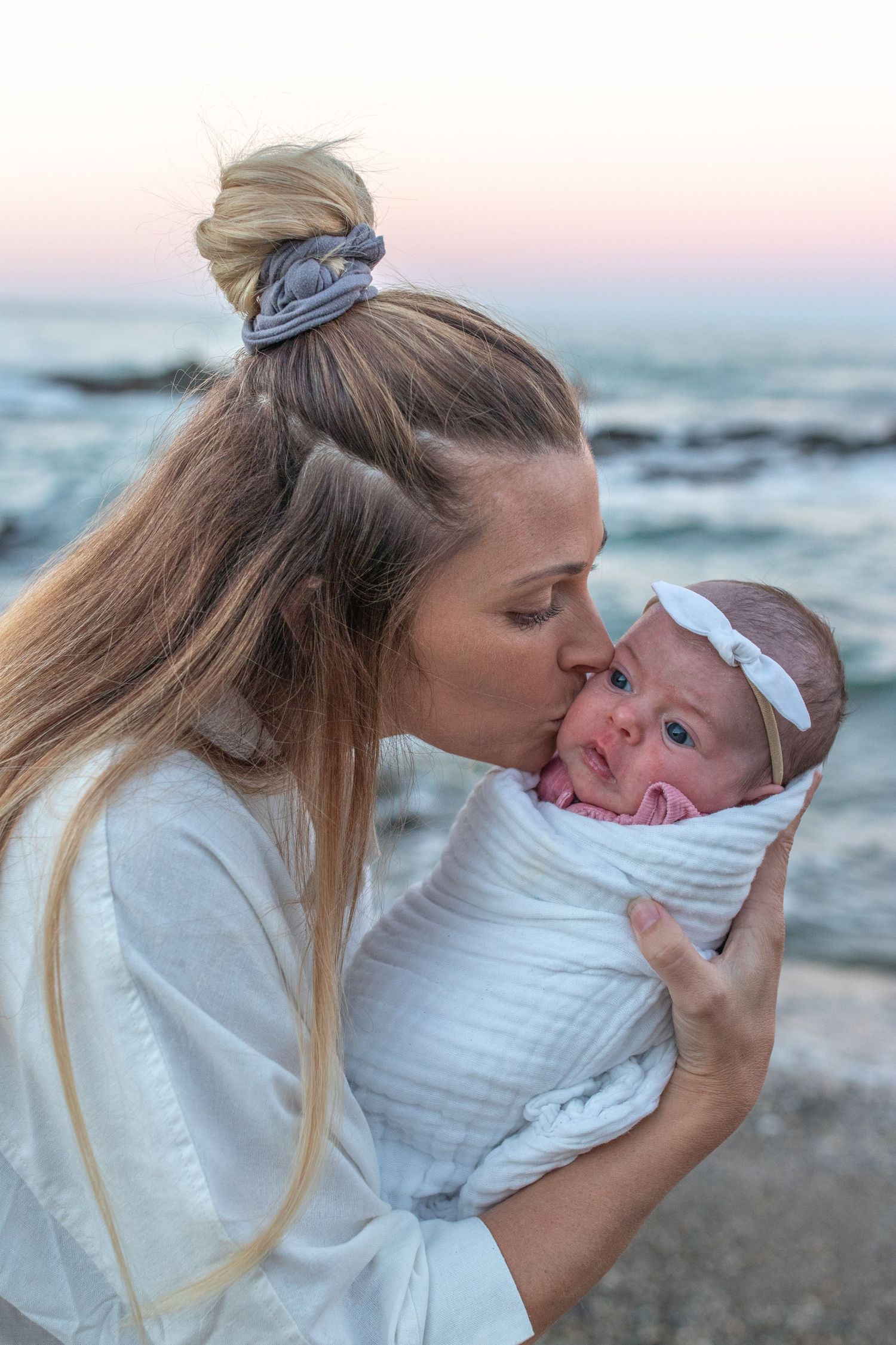 Coastal newborn session with family, featuring candid moments and gentle light.