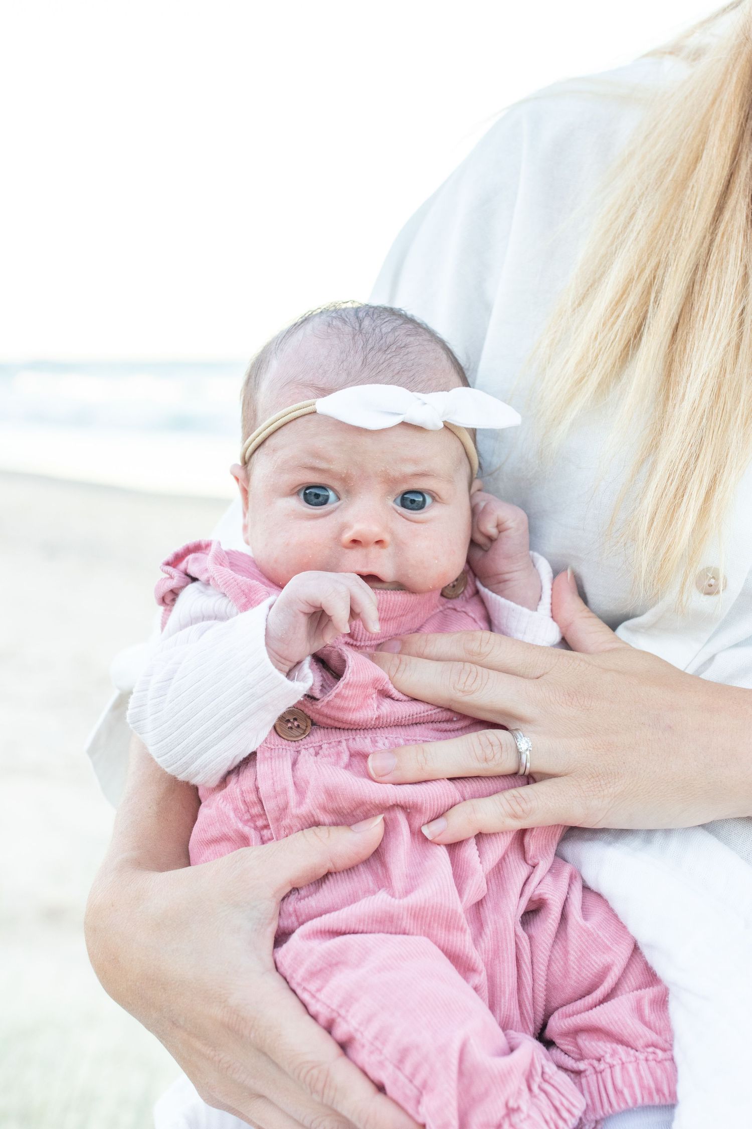 Coastal newborn session with family, featuring candid moments and gentle light.