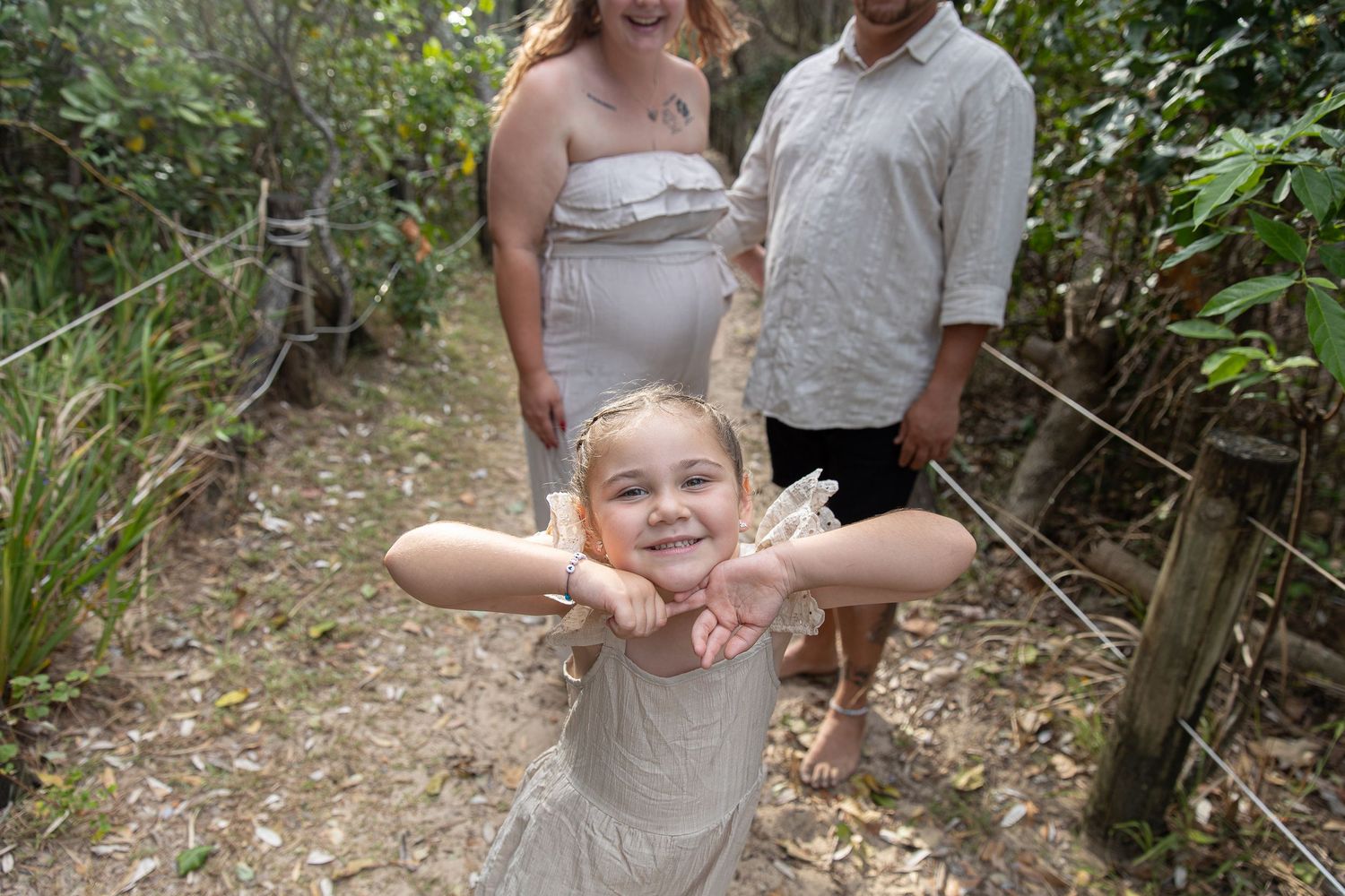 Family walking together on a shaded nature trail surrounded by greenery.