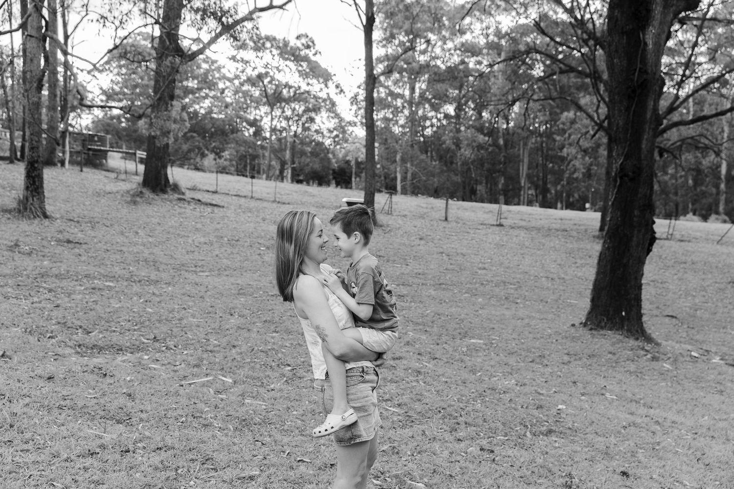 Children playing and running through a scenic wooded park area.